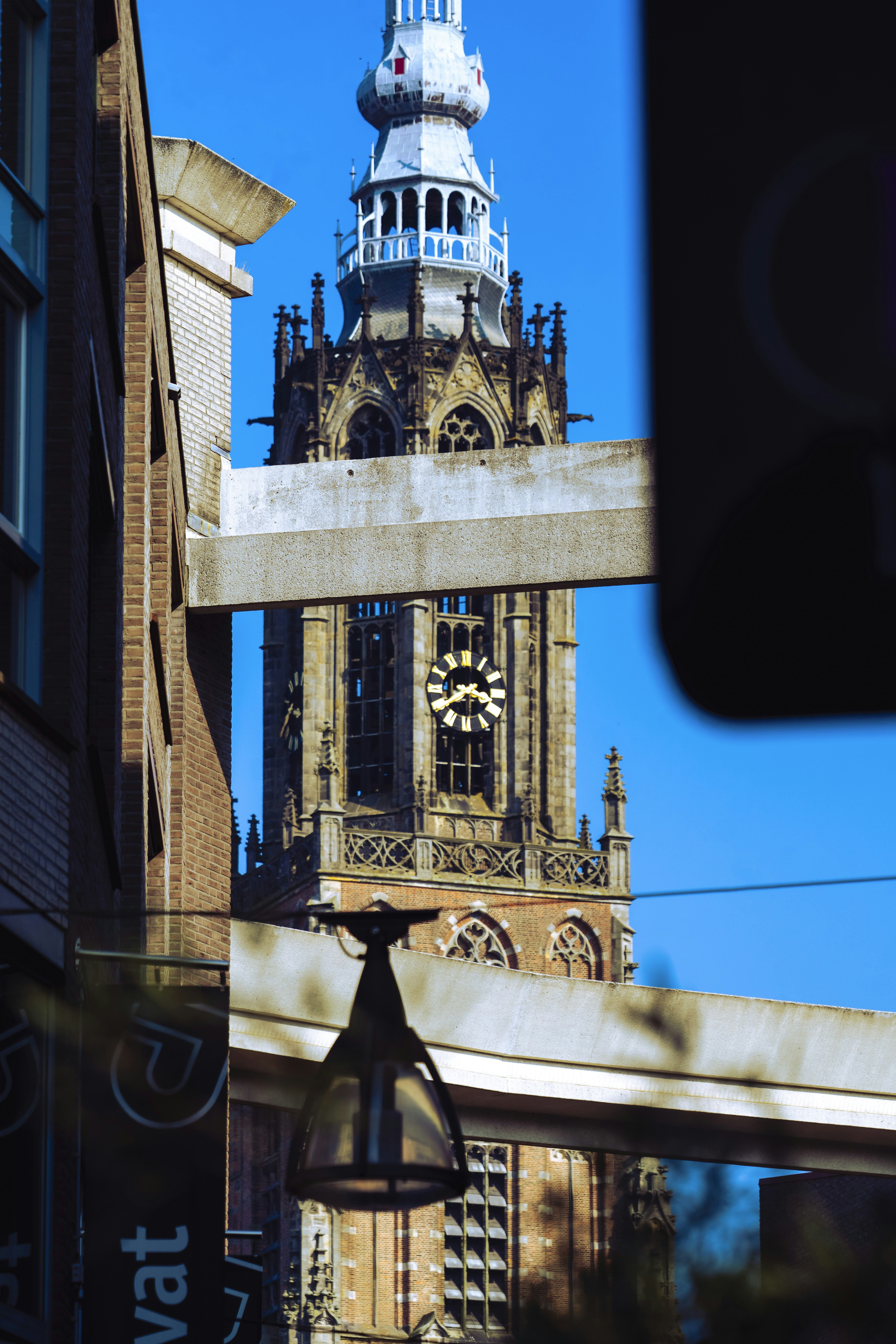 Tall church tower with clock against blue sky