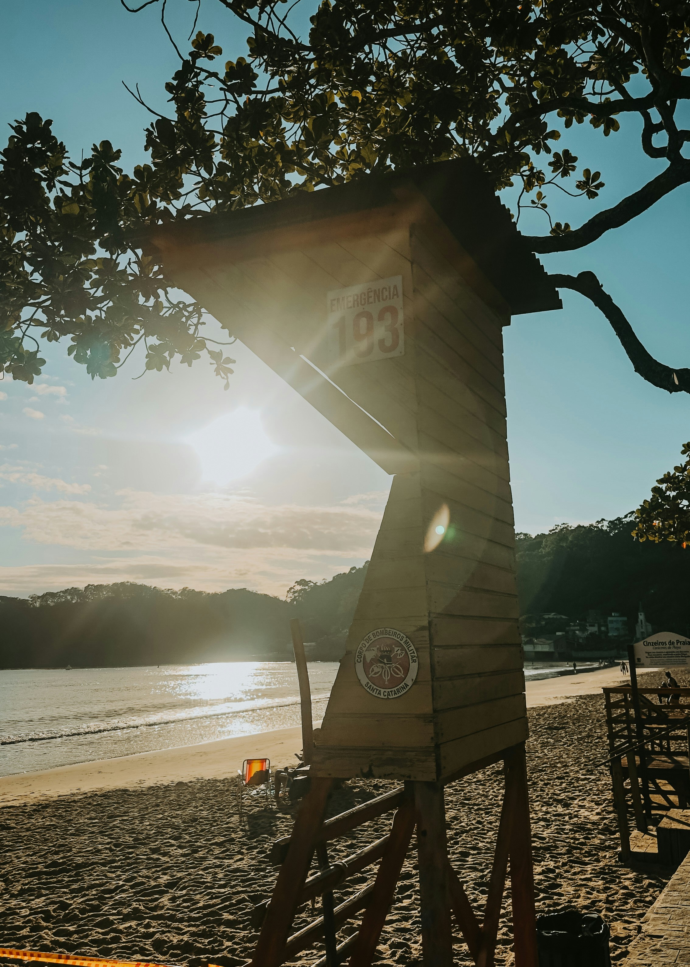 Lifeguard tower on a sandy beach at sunset.