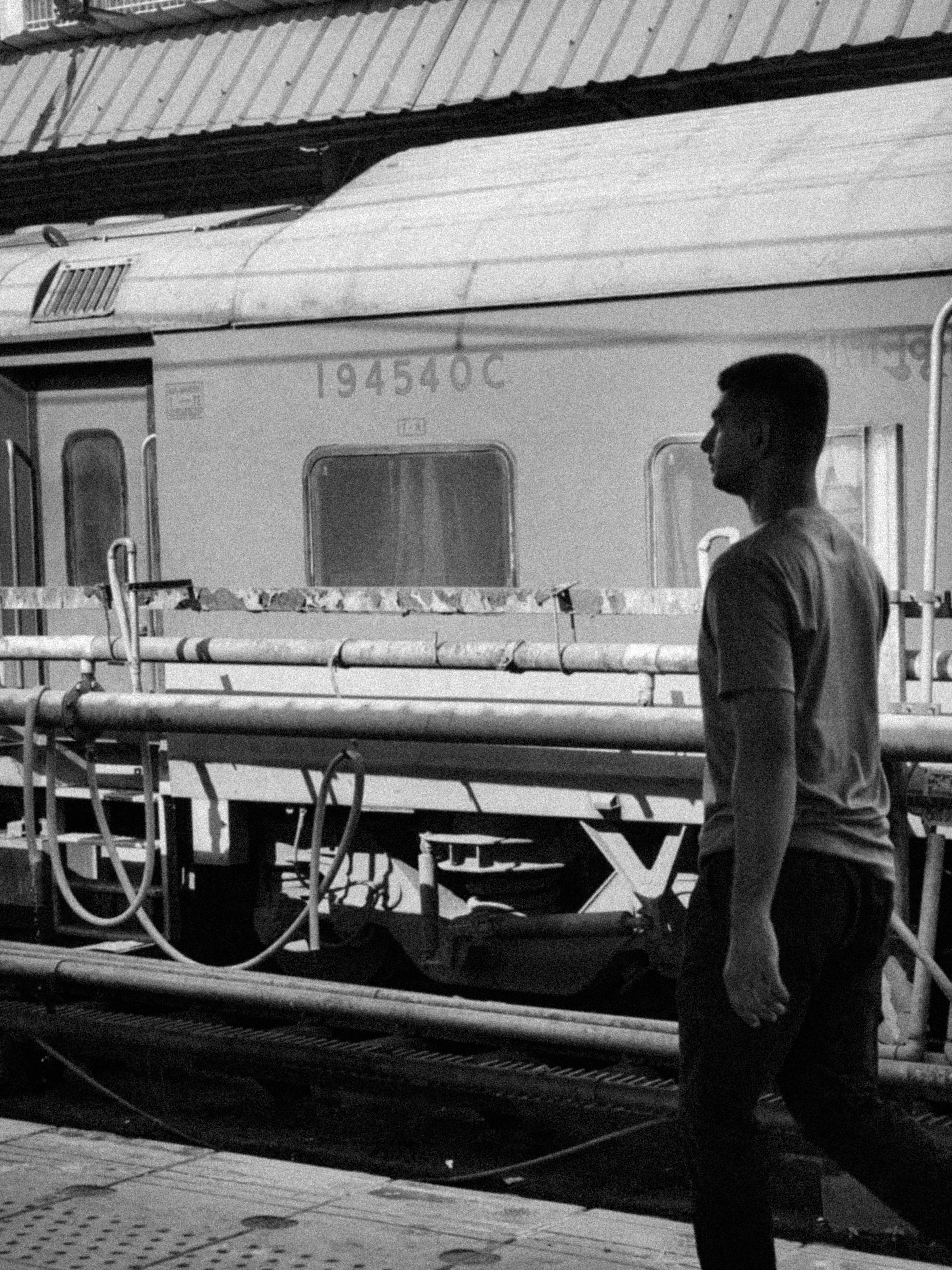 Man walks past a train at a station.