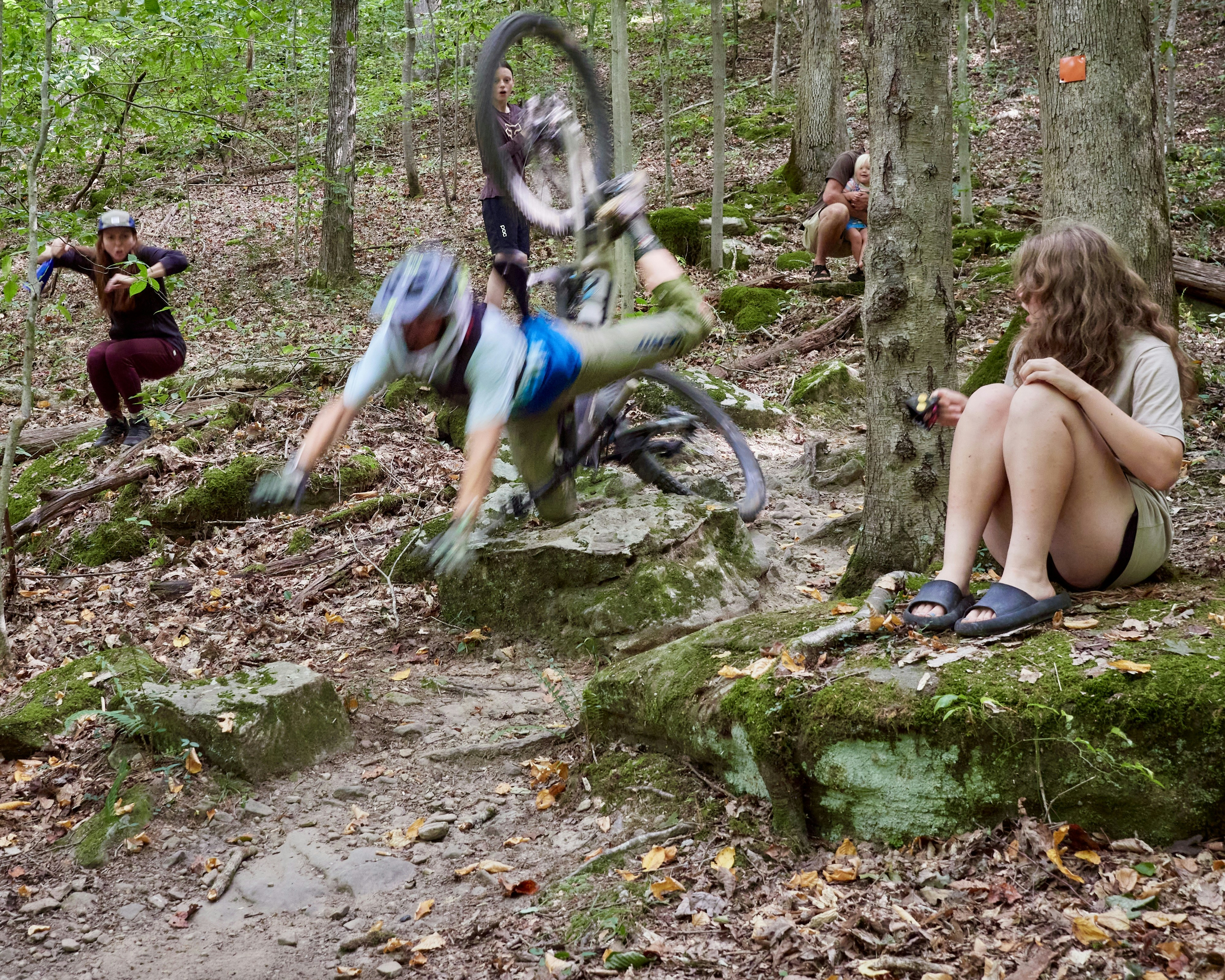 Mountain biker falls off bicycle on rocky trail