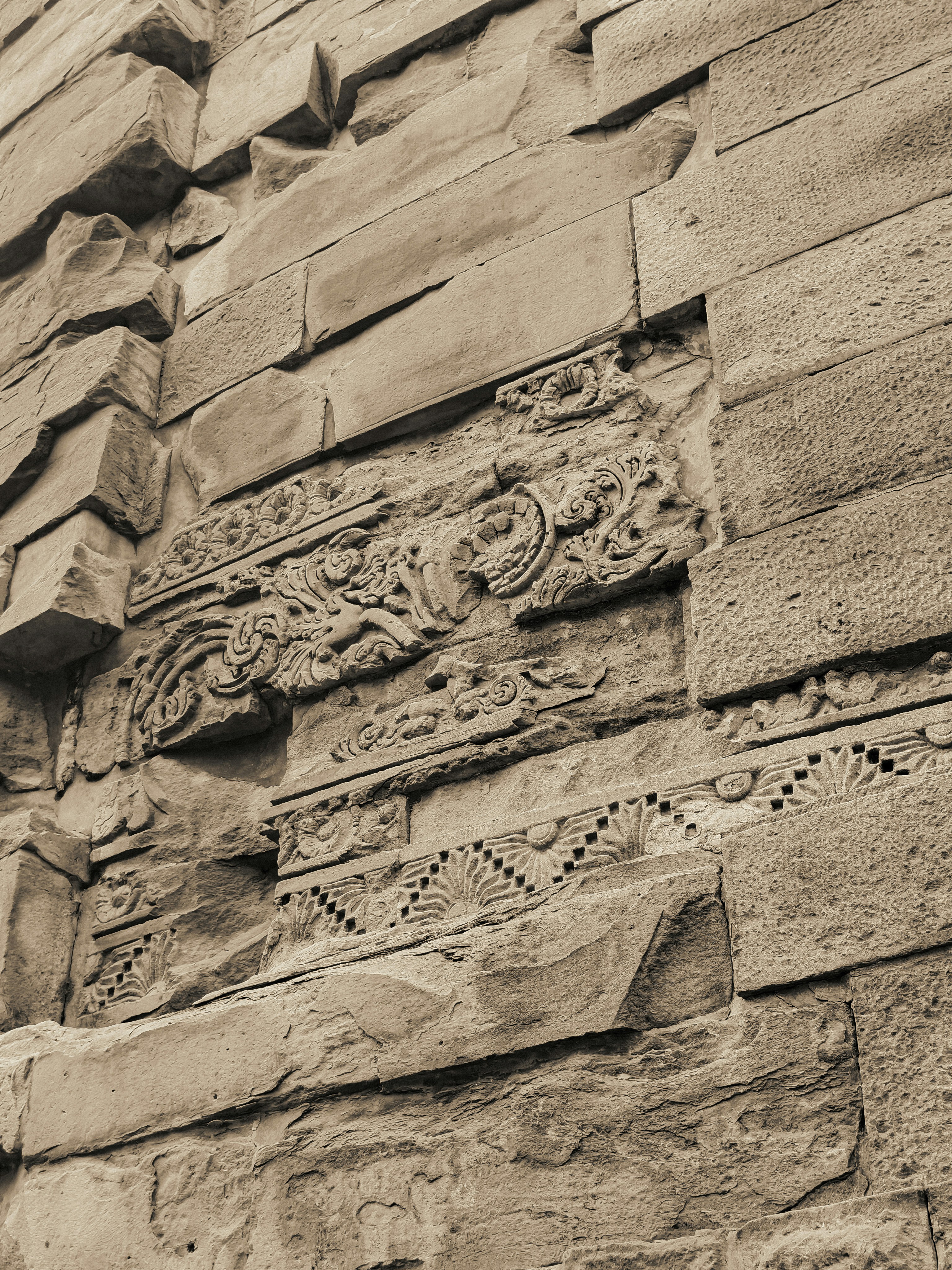 Close up of ancient stone wall with intricate carvings.