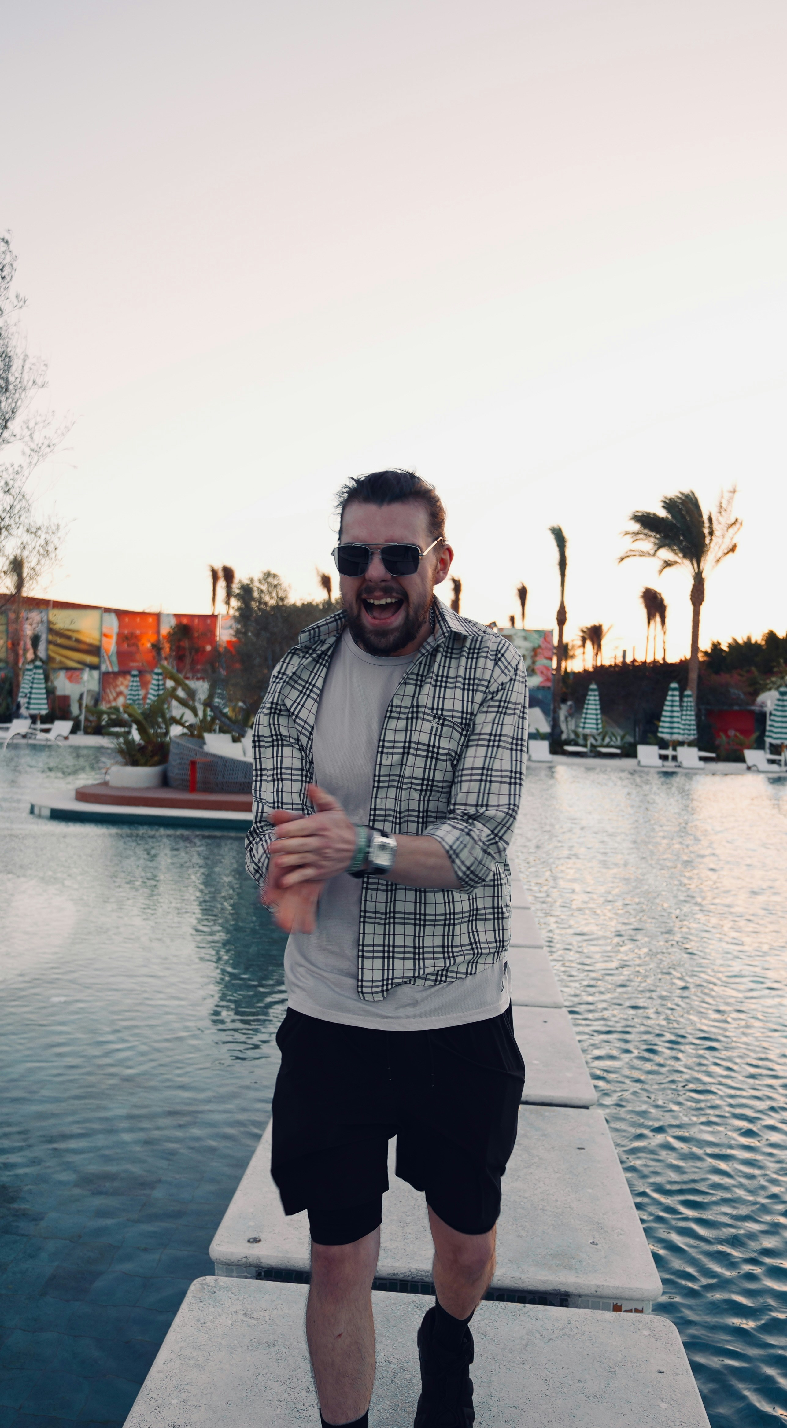 Man walking on stepping stones over water at sunset