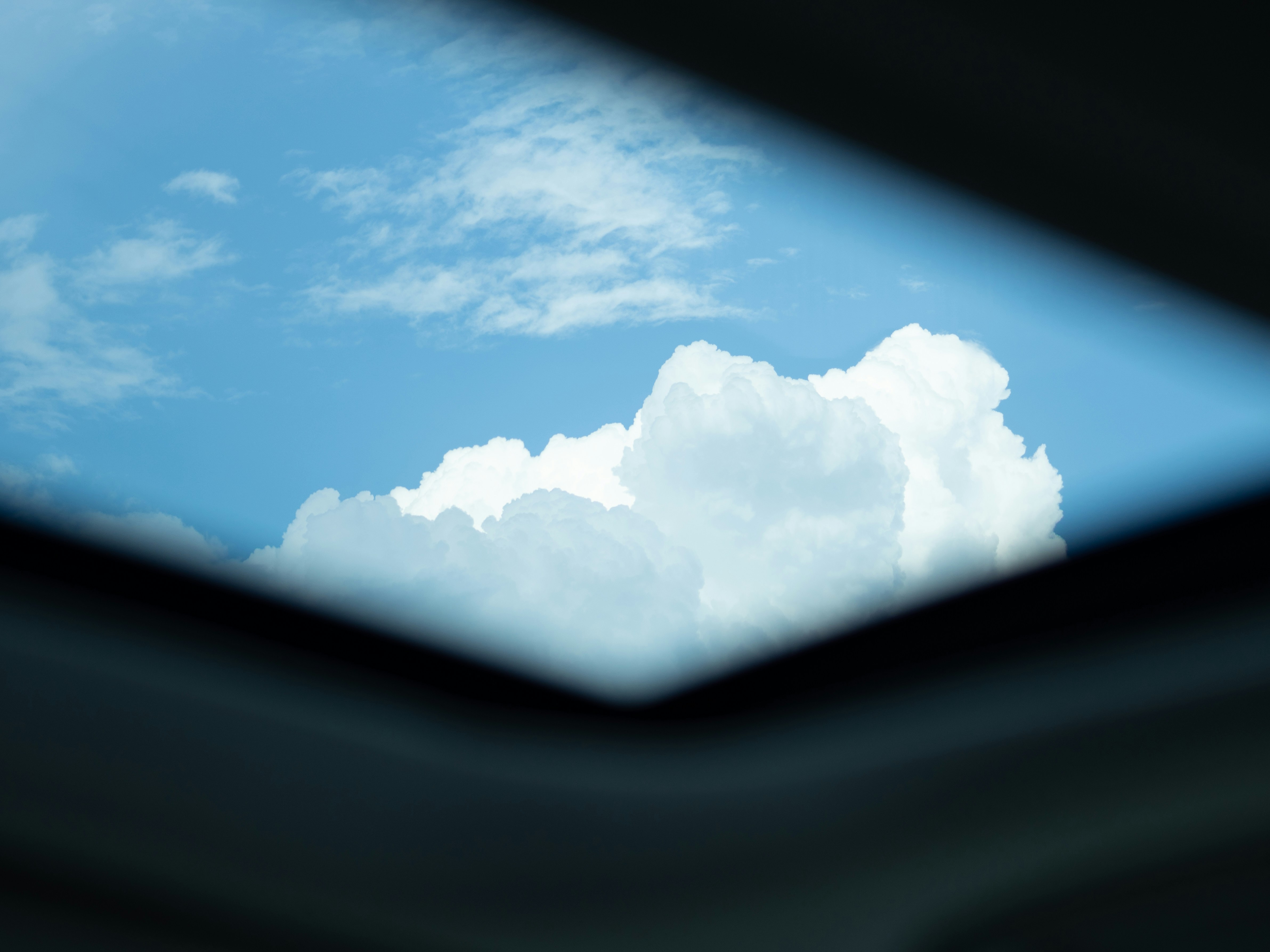 明るい青空を背景にふわふわとした白い雲。