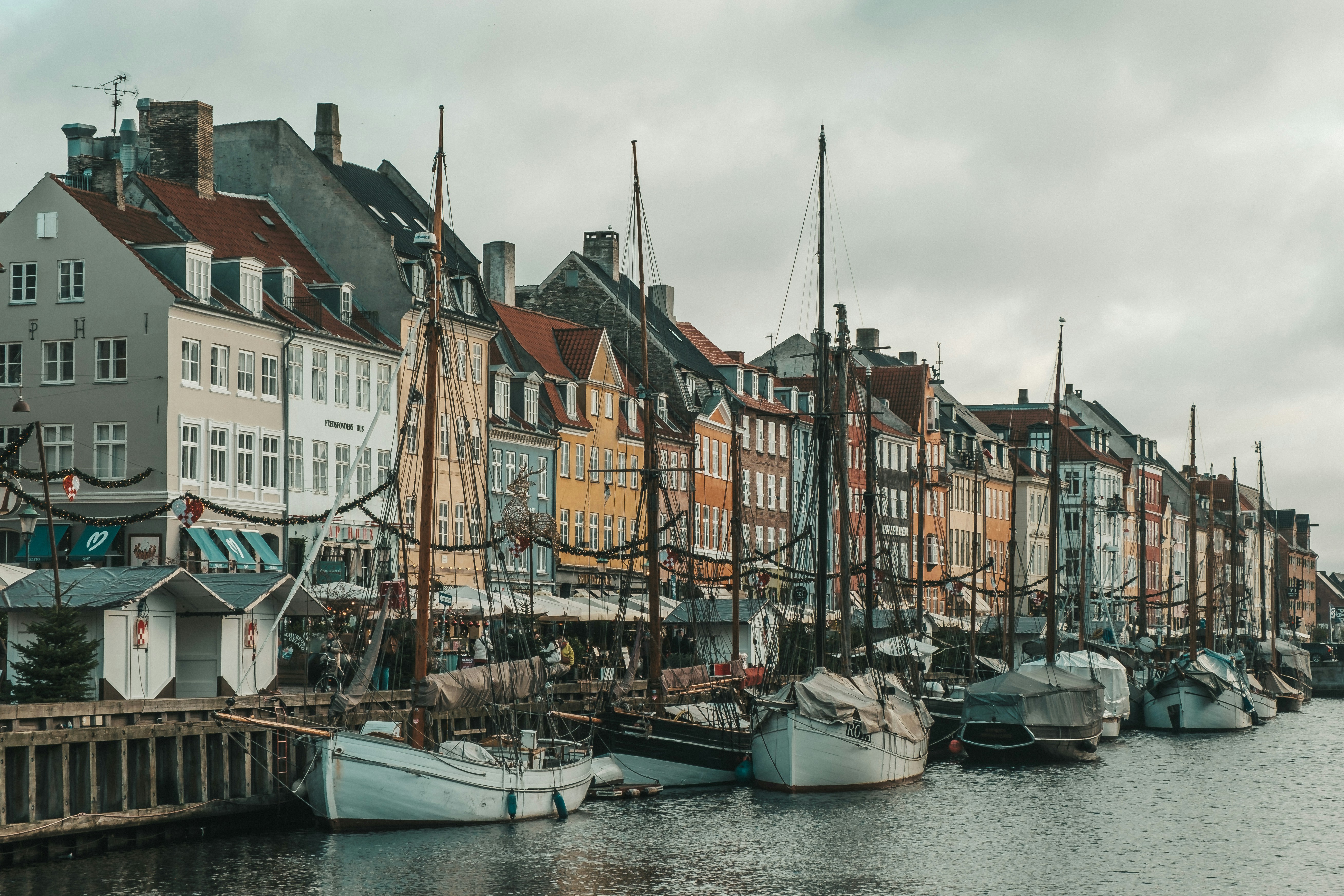 Colorful buildings line a canal with docked boats.