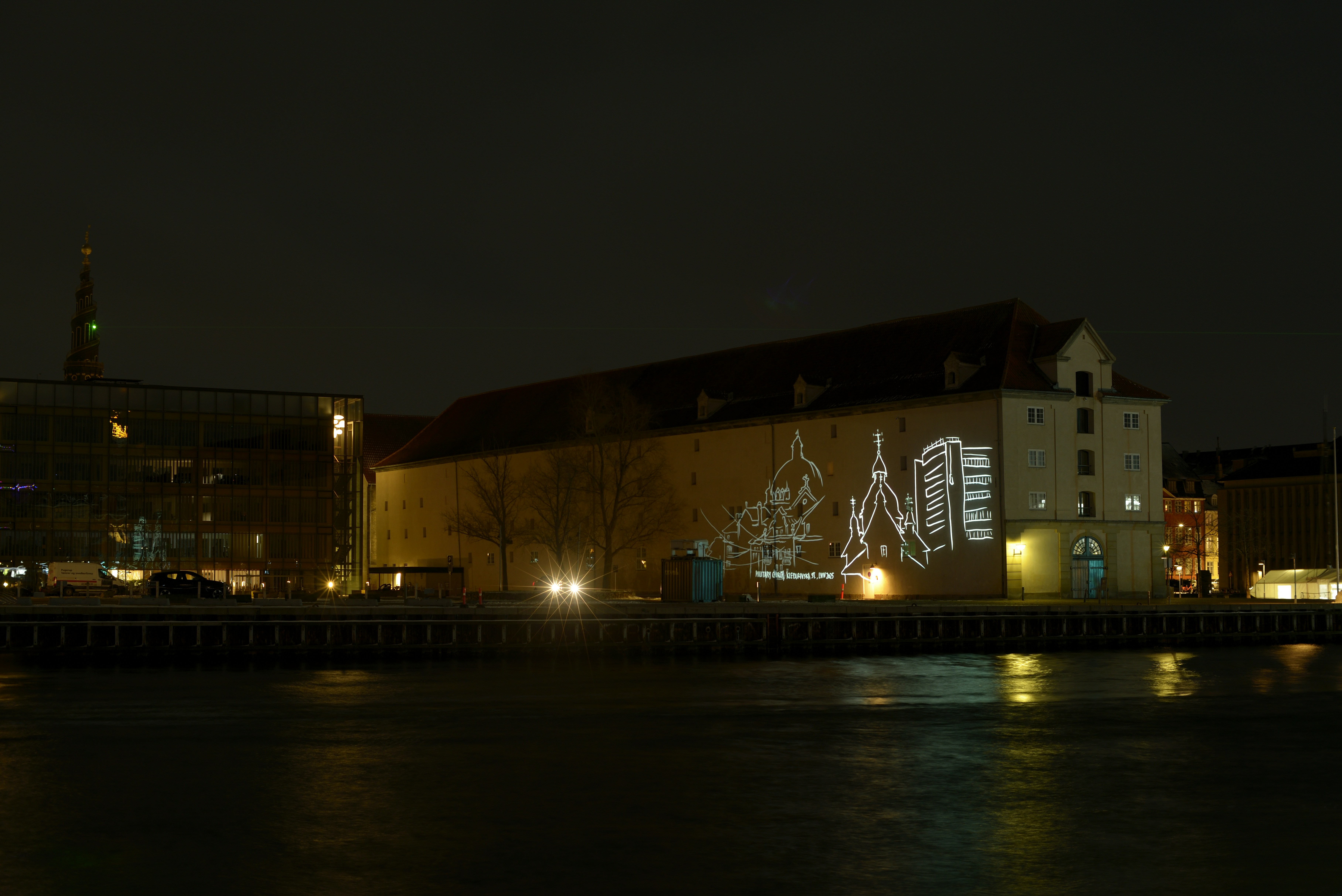 Building illuminated with white light projections at night