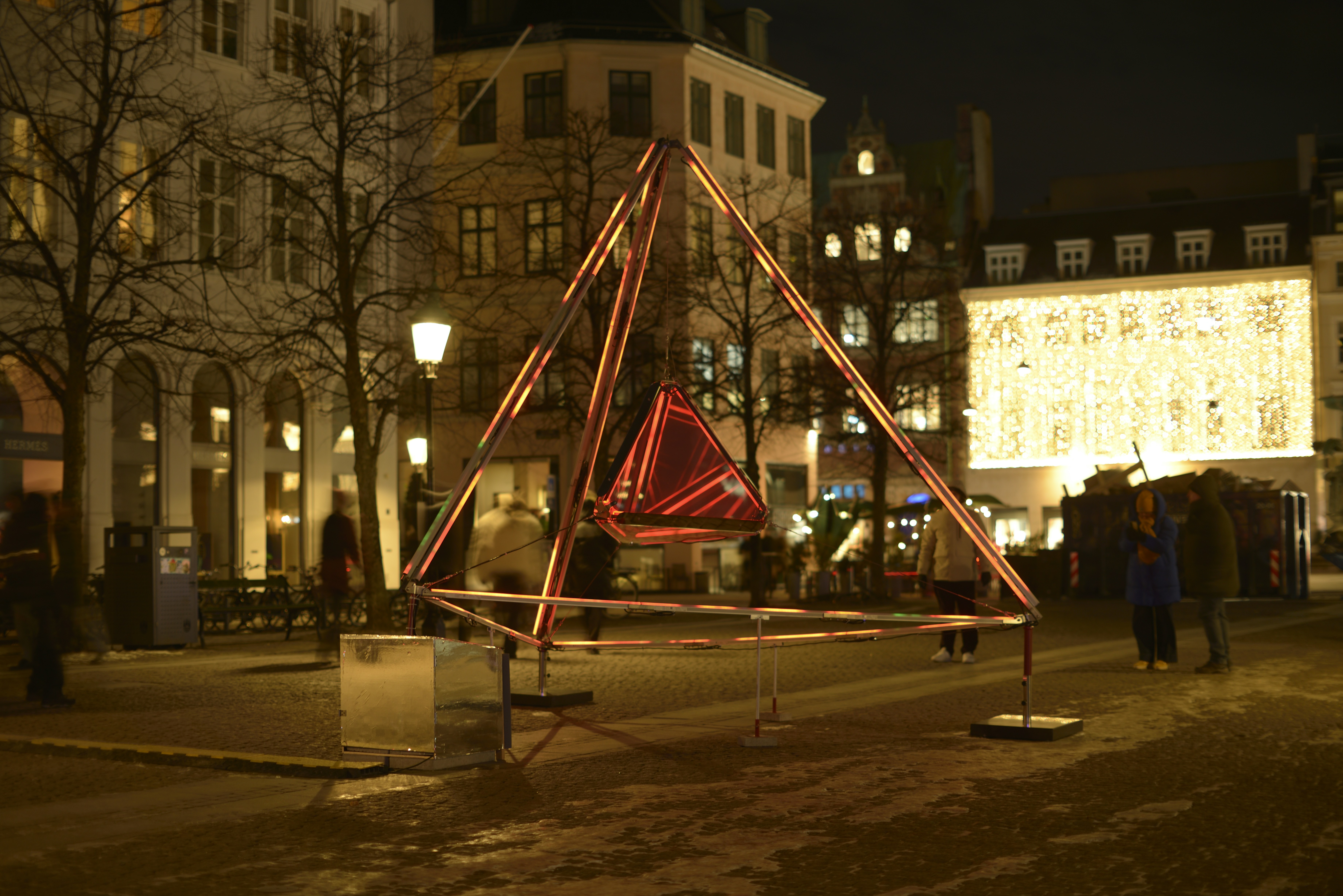 Mani Nikel – Denmark This is a geometric light sculpture composed of an illuminated inner tetrahedron – a four-sided pyramid, enclosing a mirrored form. As viewers move around the work, their perception changes. The light gradually changes, creating reflections that multiply the space and fragment the mirrored images. Copenhagen Light Festival is an annual light festival that transforms the quiet and cold winter darkness into a unique celebration of light art, lighting design and illumination in the center of Copenhagen.