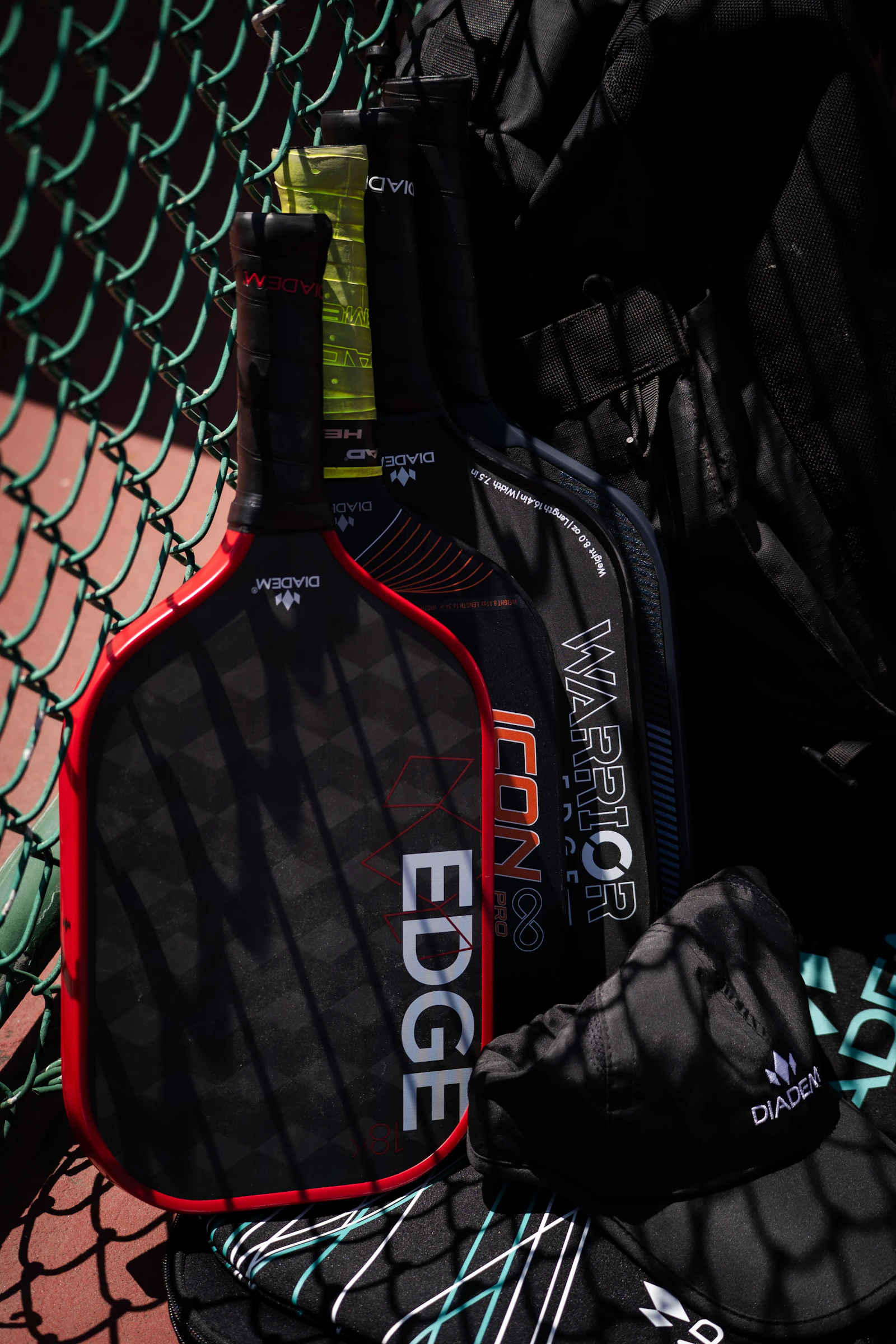 Illustrative photograph of pickleball paddles beside a court