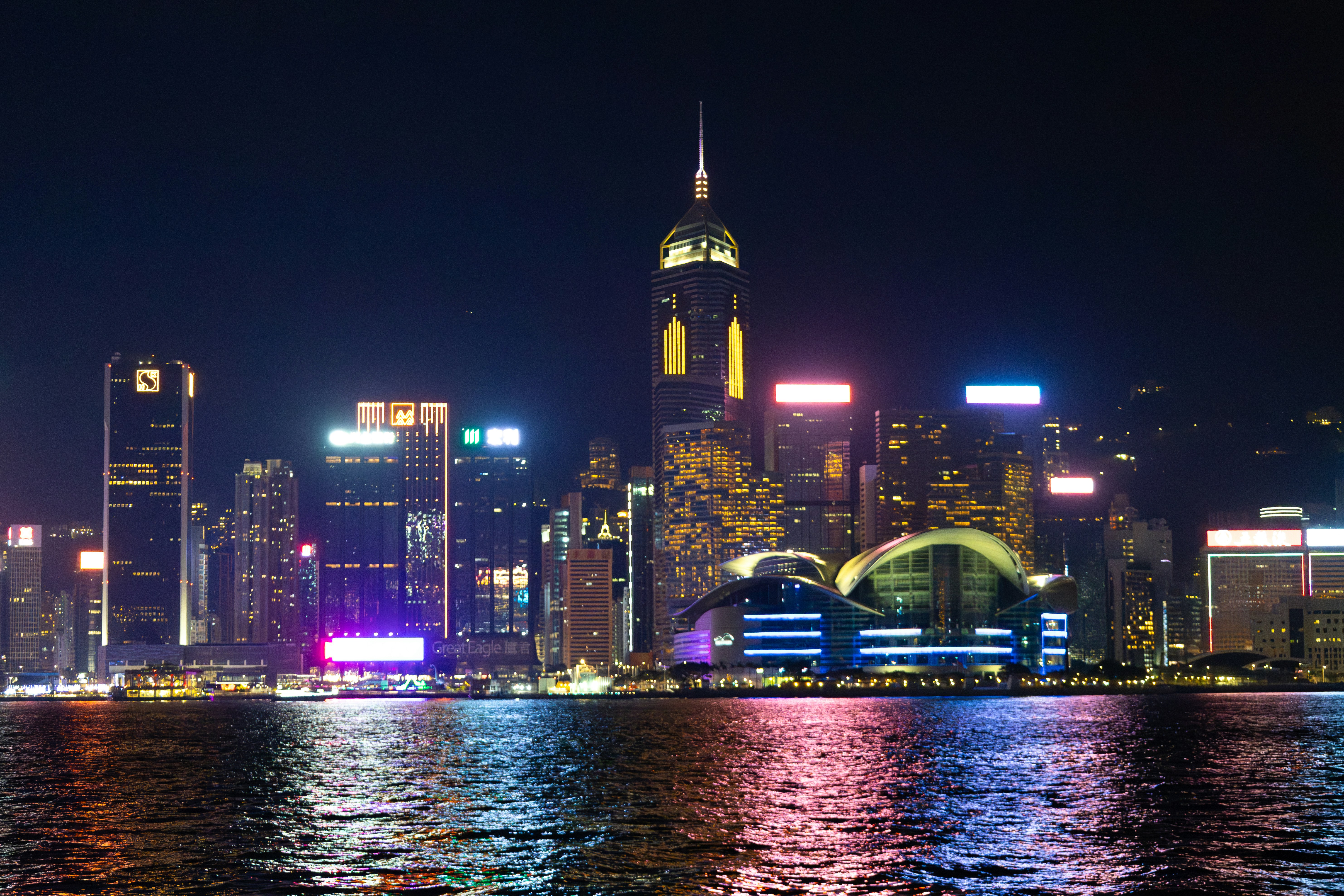Un paisaje urbano vibrante con rascacielos iluminados por la noche.