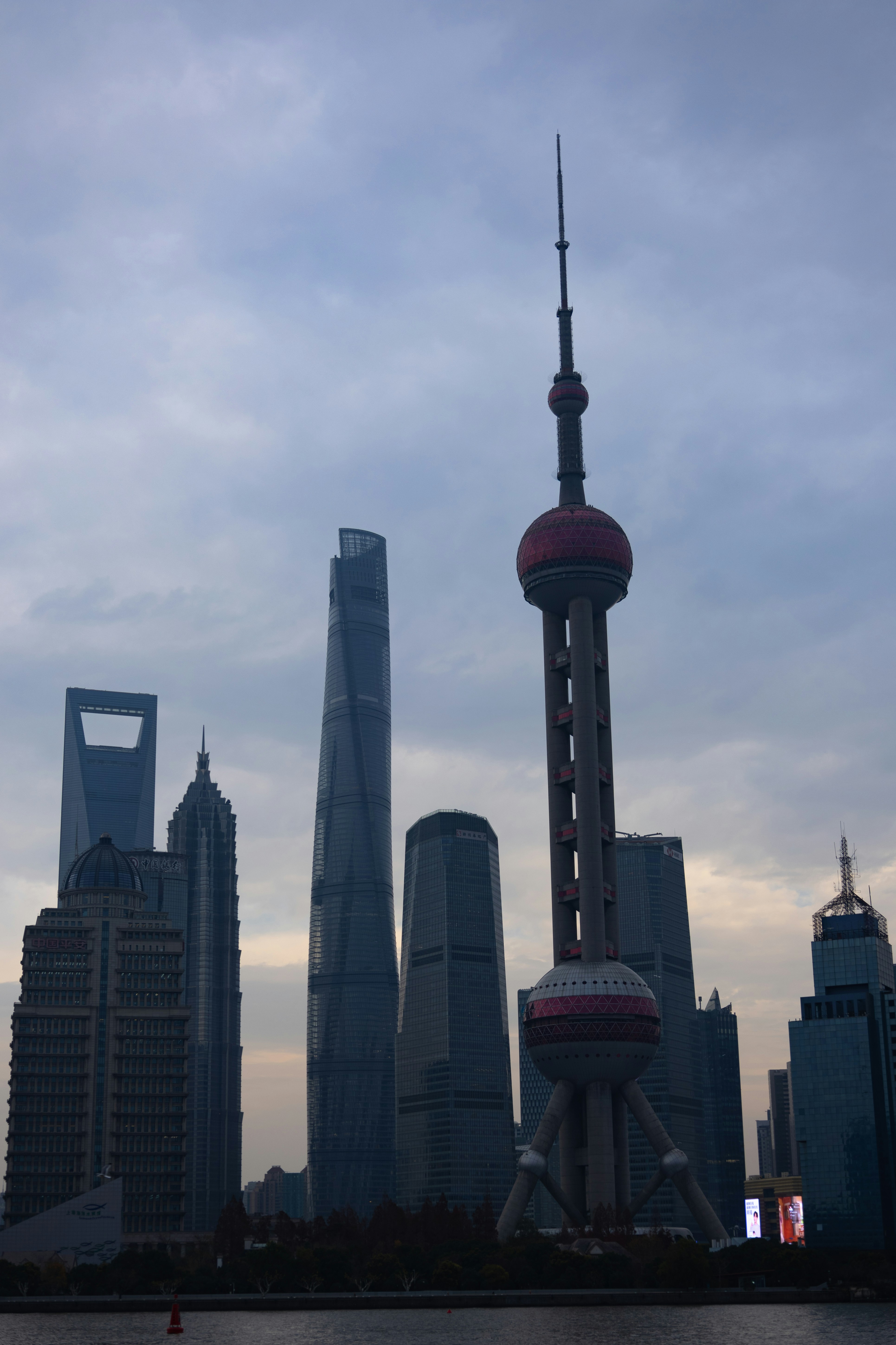 Rascacielos modernos y torre de perlas orientales contra cielo nublado