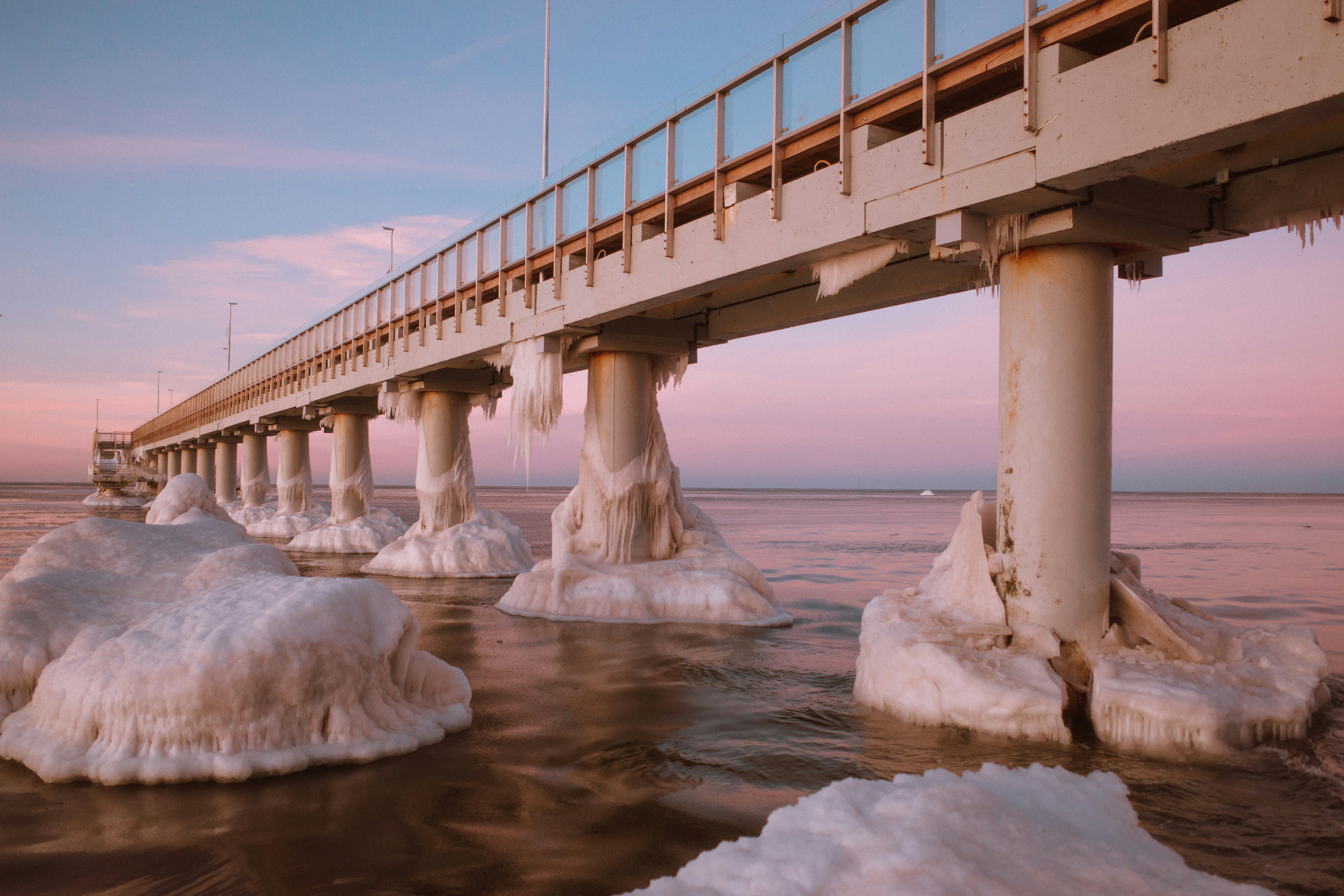 Un long quai recouvert de glace au-dessus de l’océan