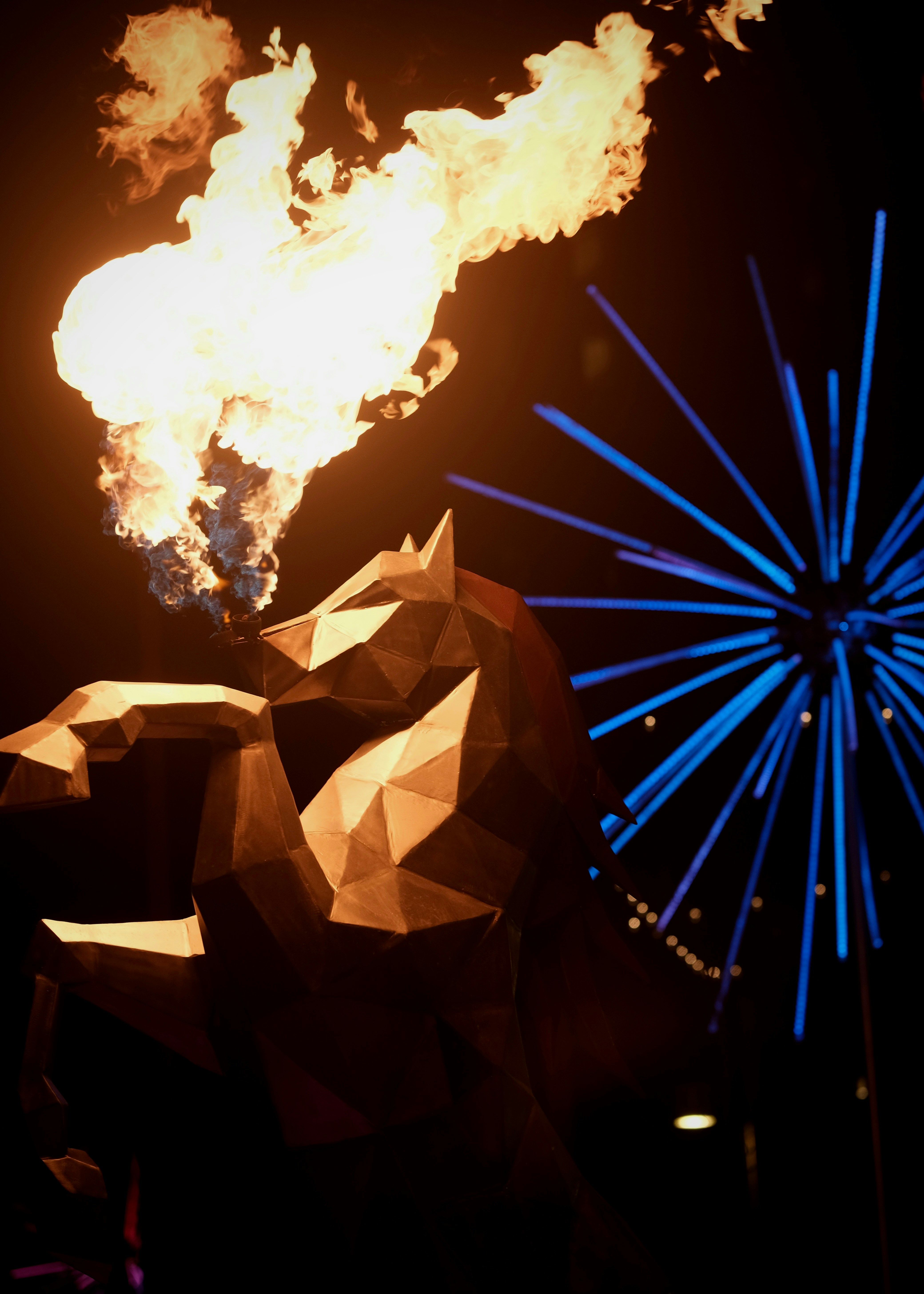 Scultura geometrica del leone che sputa fuoco con fuochi d'artificio blu