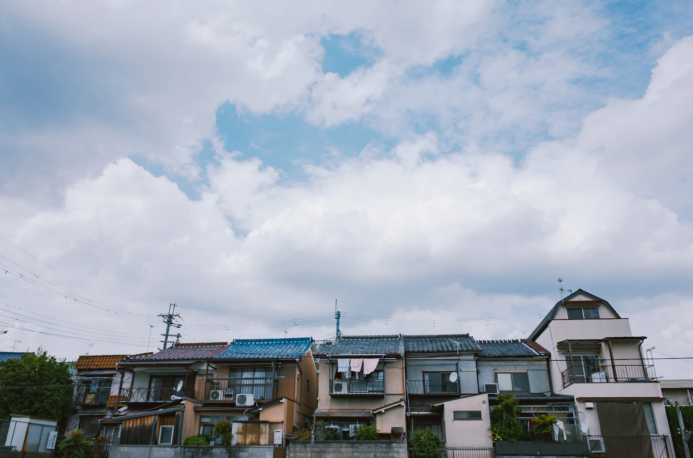 Homes under a bright sky with scattered clouds