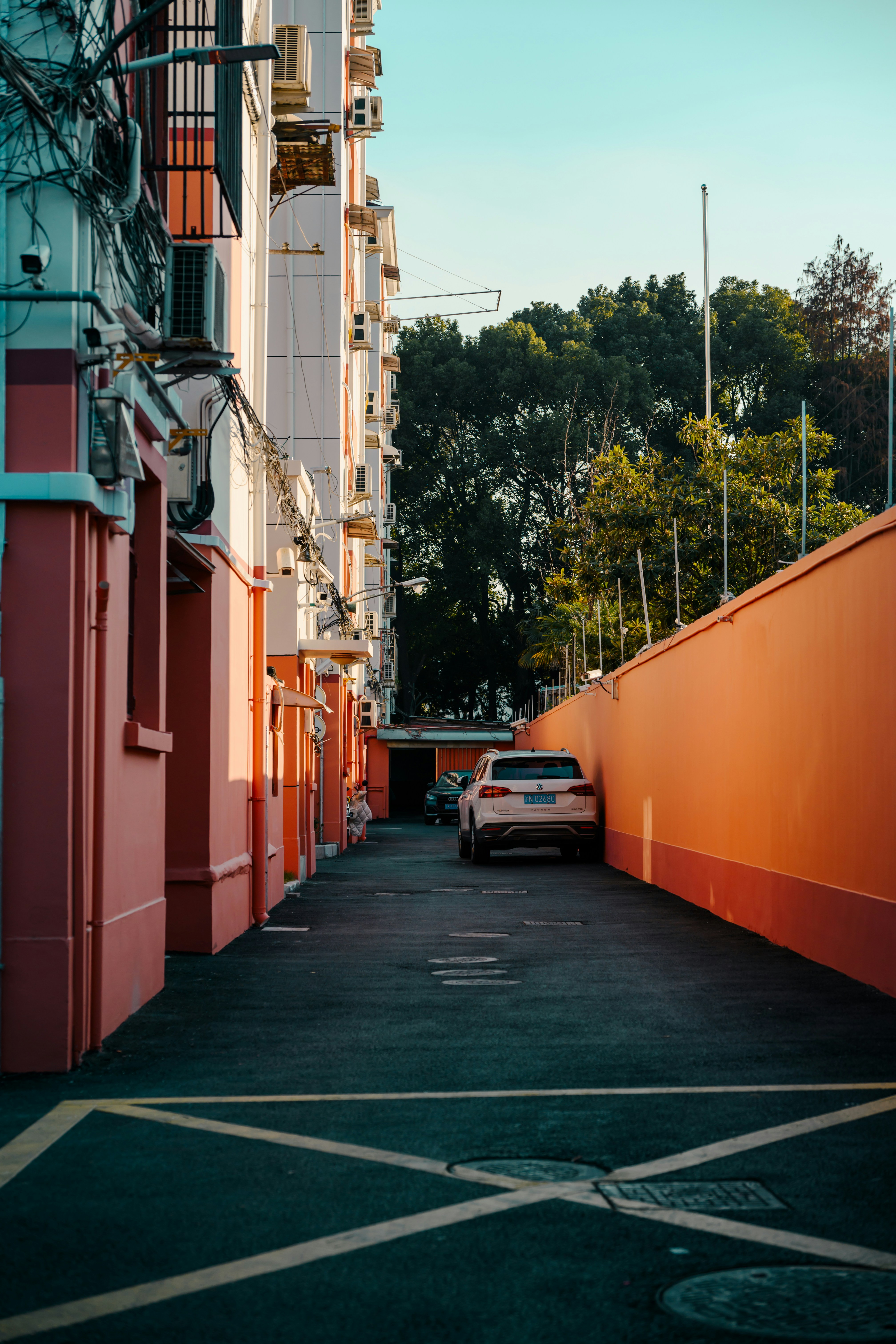 Eine schmale Gasse mit einem geparkten Auto und Gebäuden.