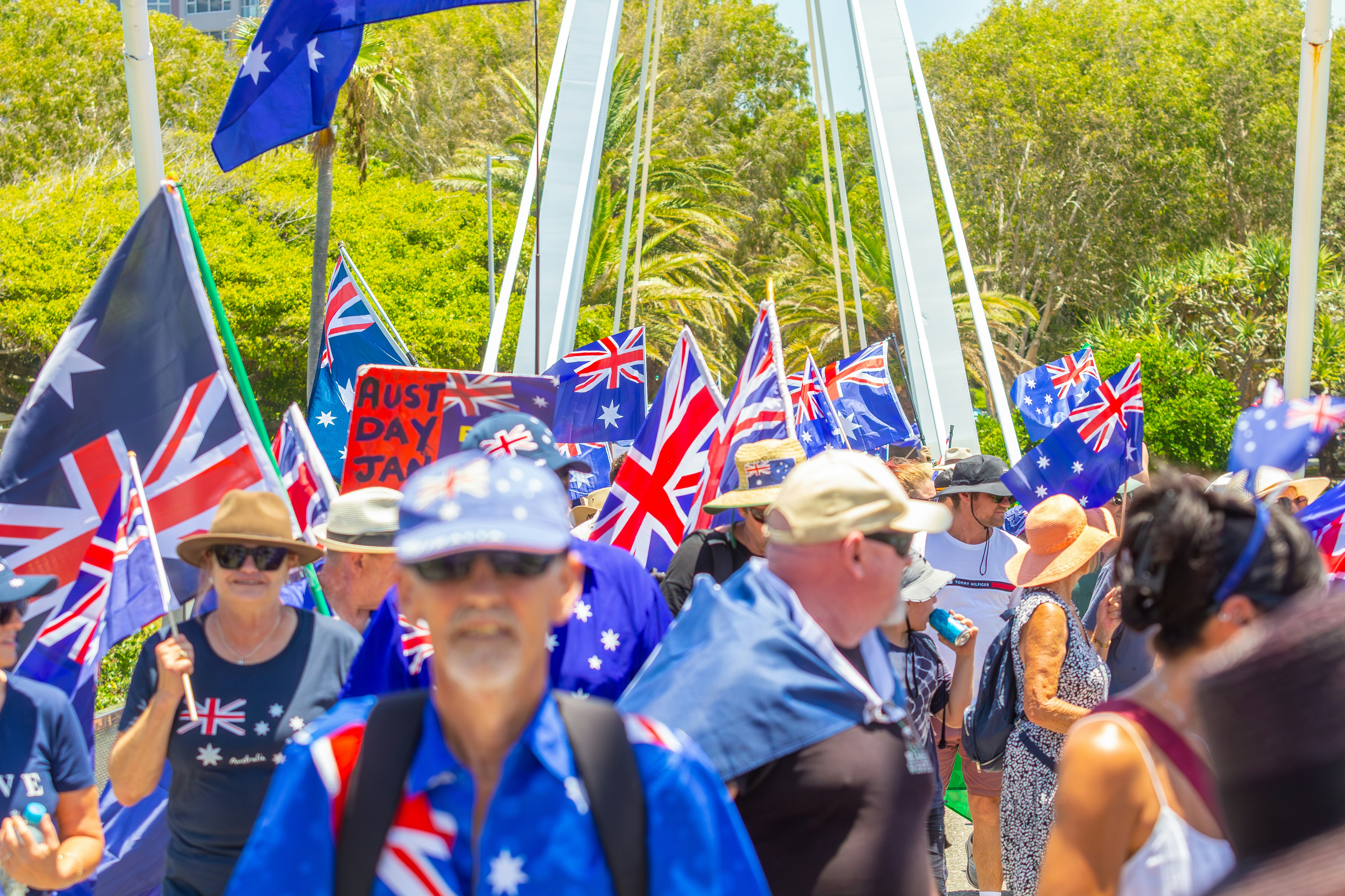 Crowd of people waving australian flags outdoors