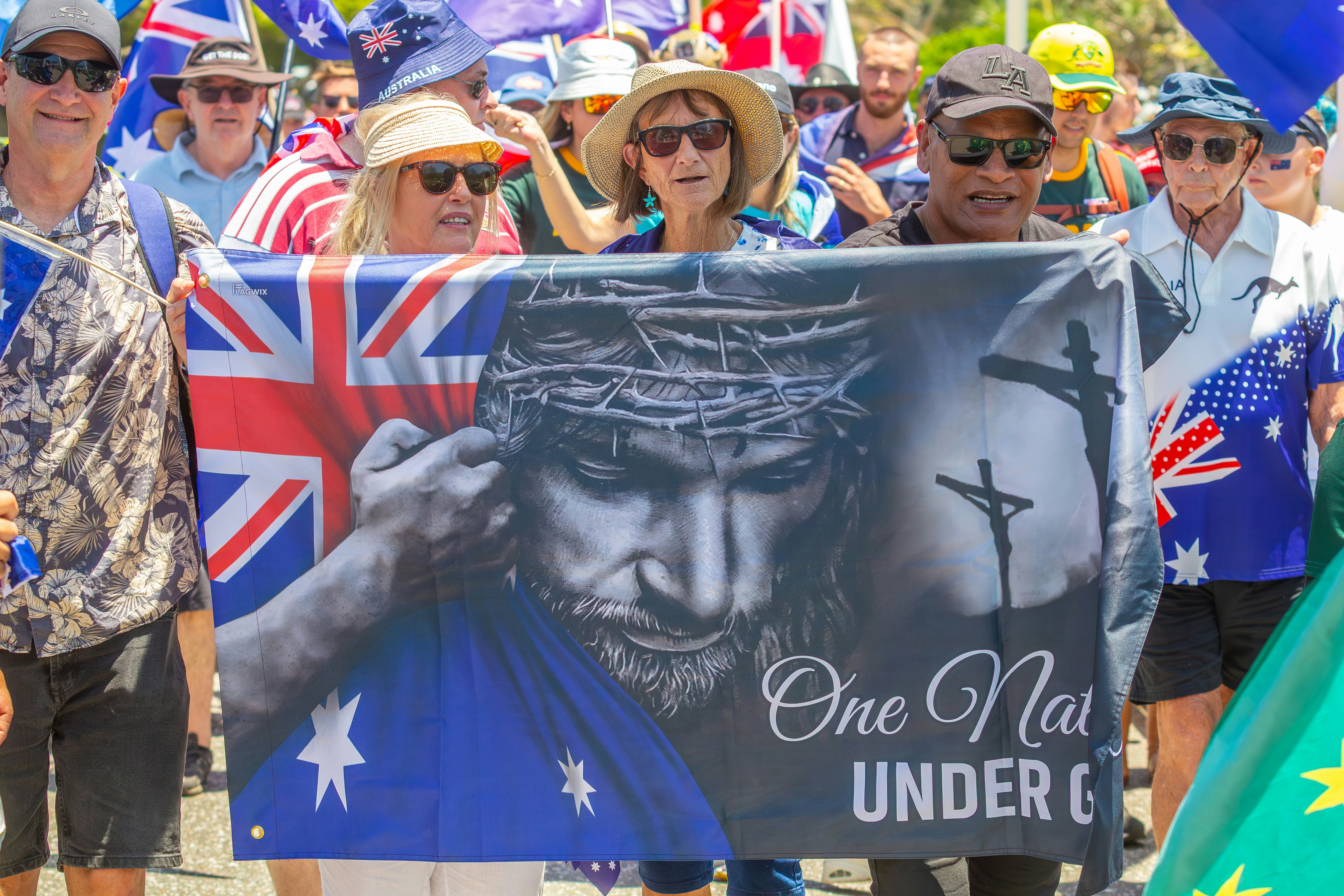 People holding a banner with jesus and australian flags.
