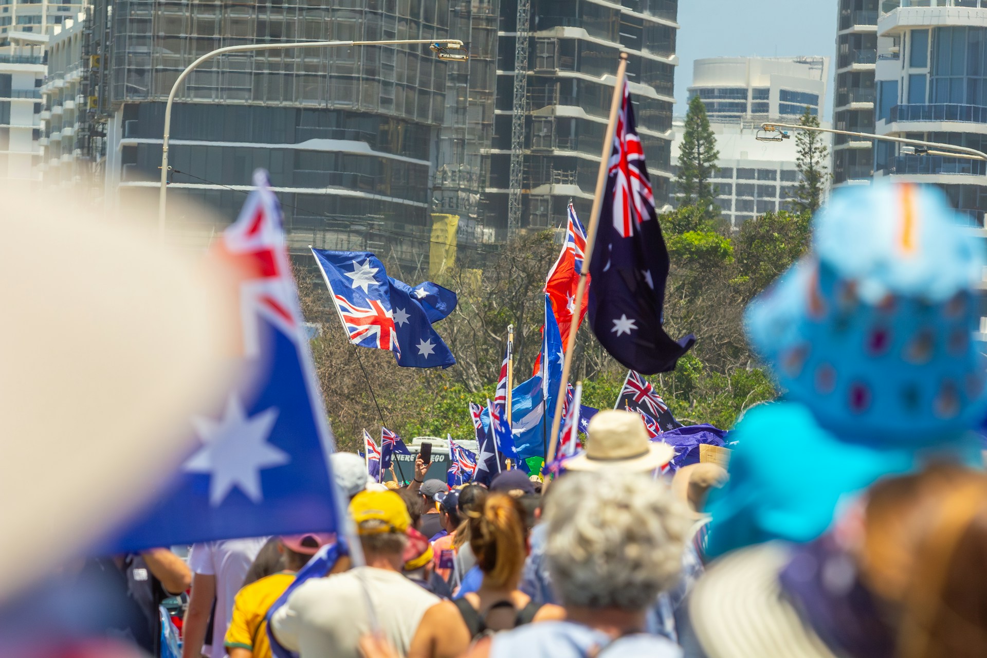 Crowd of people waving australian flags at an outdoor event