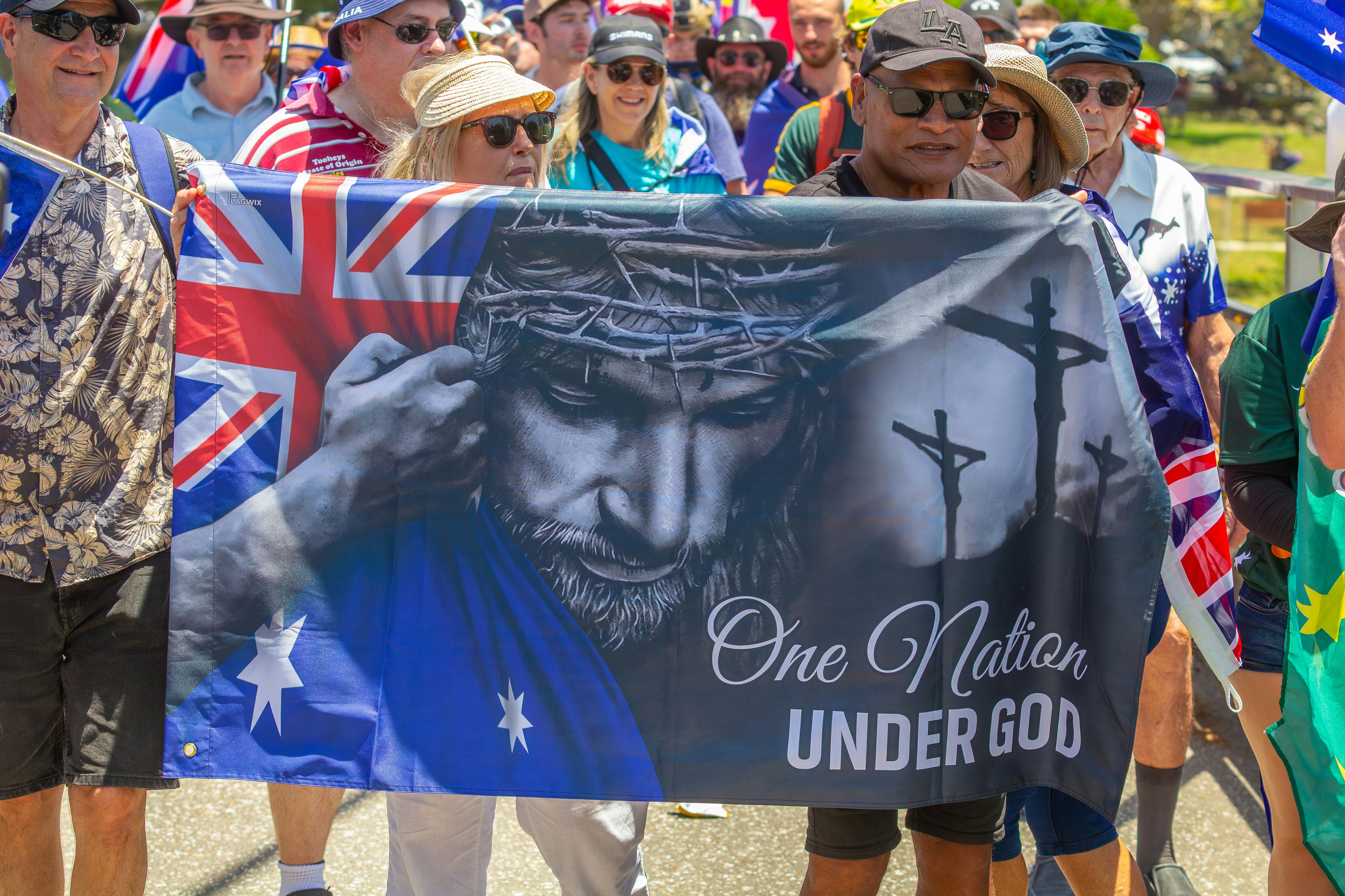 People holding a banner with jesus and australian flag.