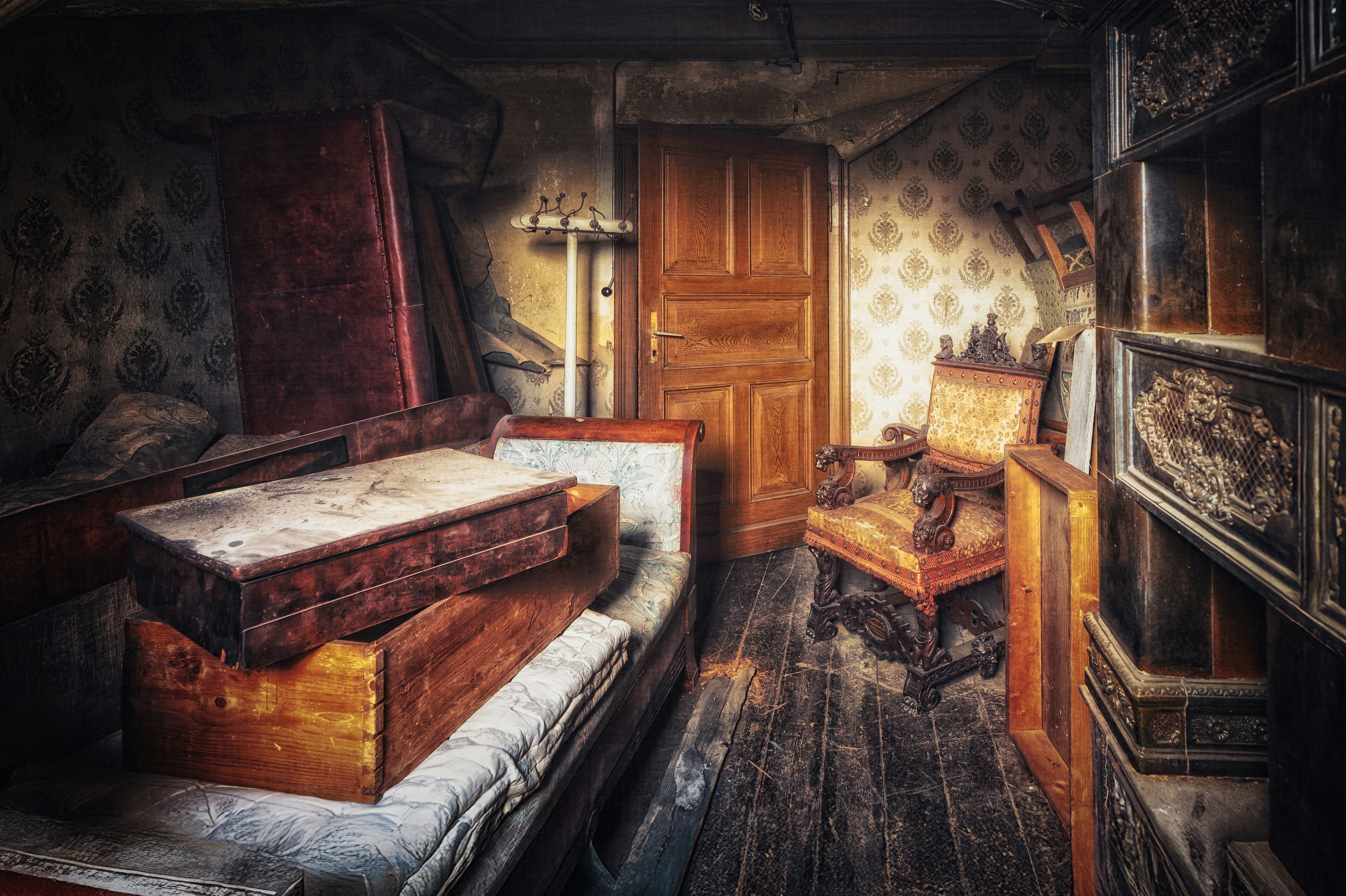 Abandoned room with dusty furniture and old wallpaper.