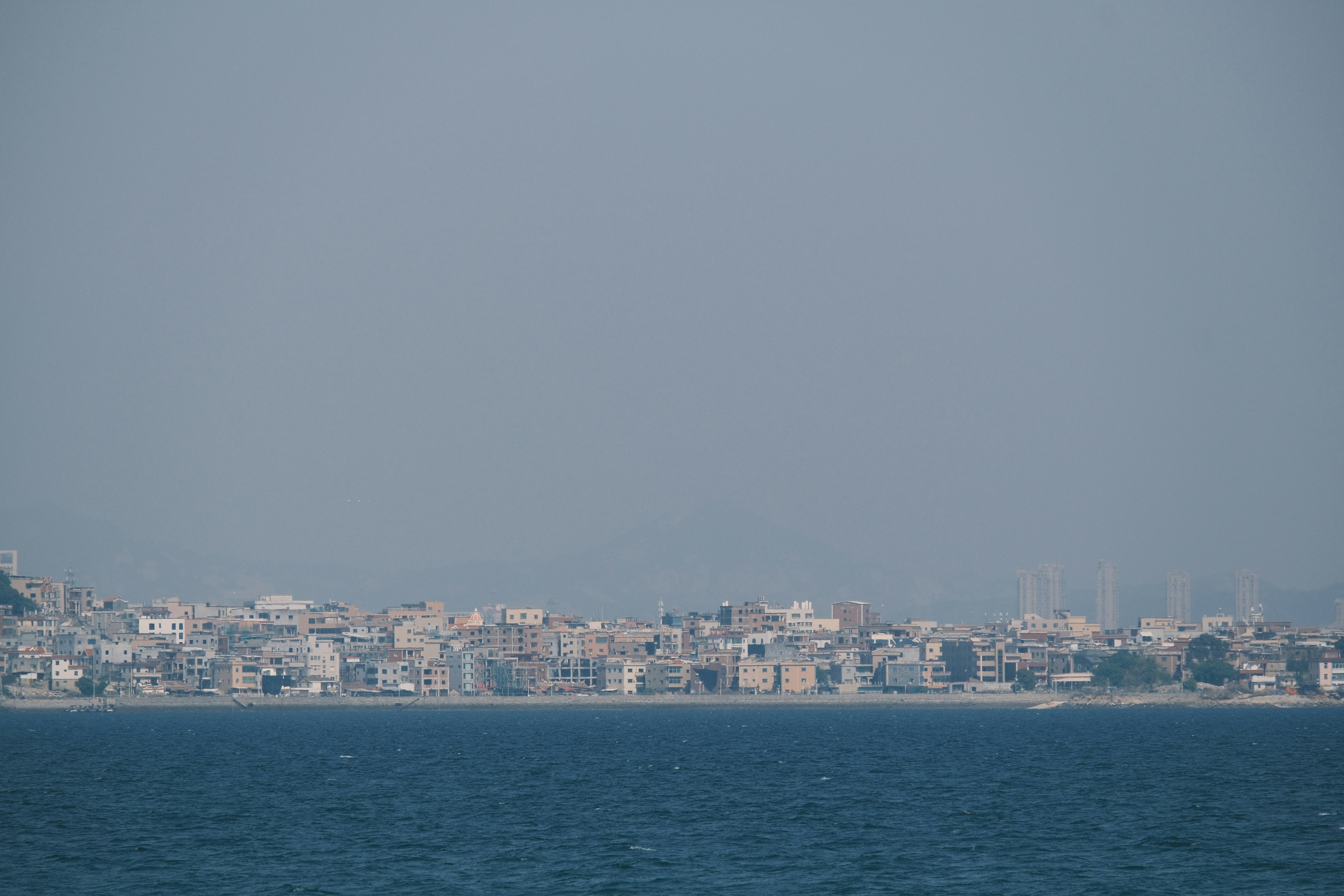Coastal city skyline with buildings along the water