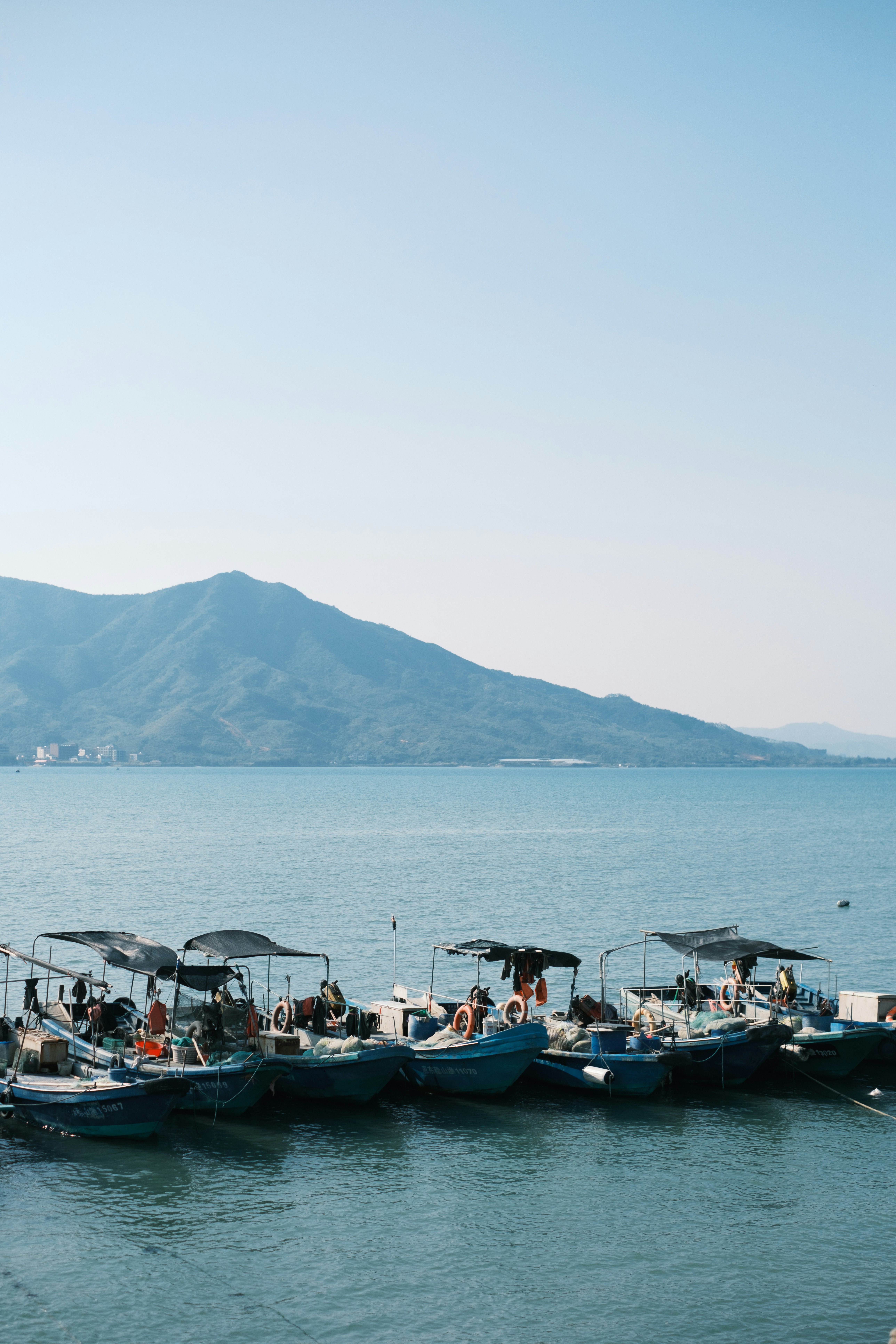 Fishing boats docked in a calm blue bay