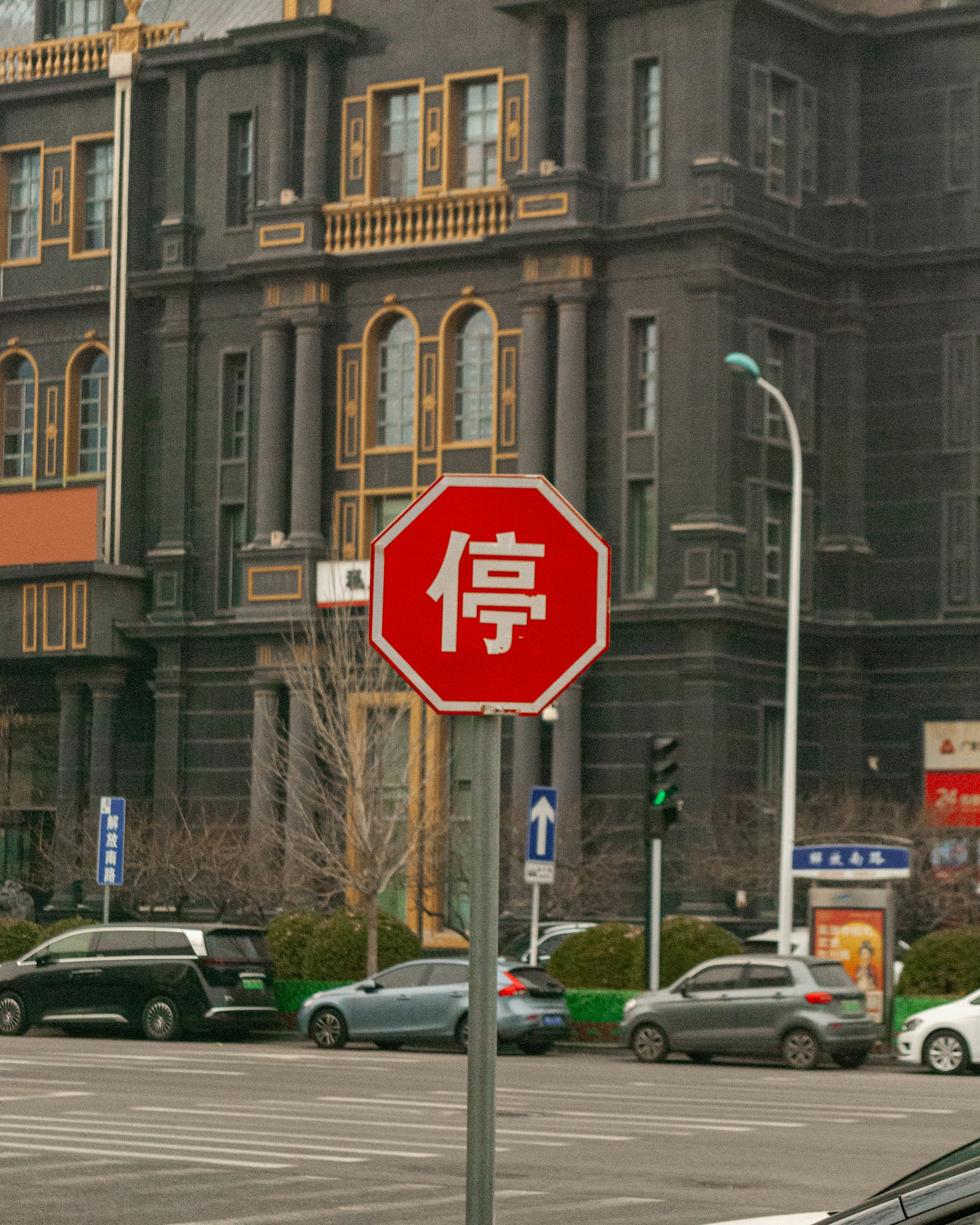 Red stop sign with chinese characters in front of building
