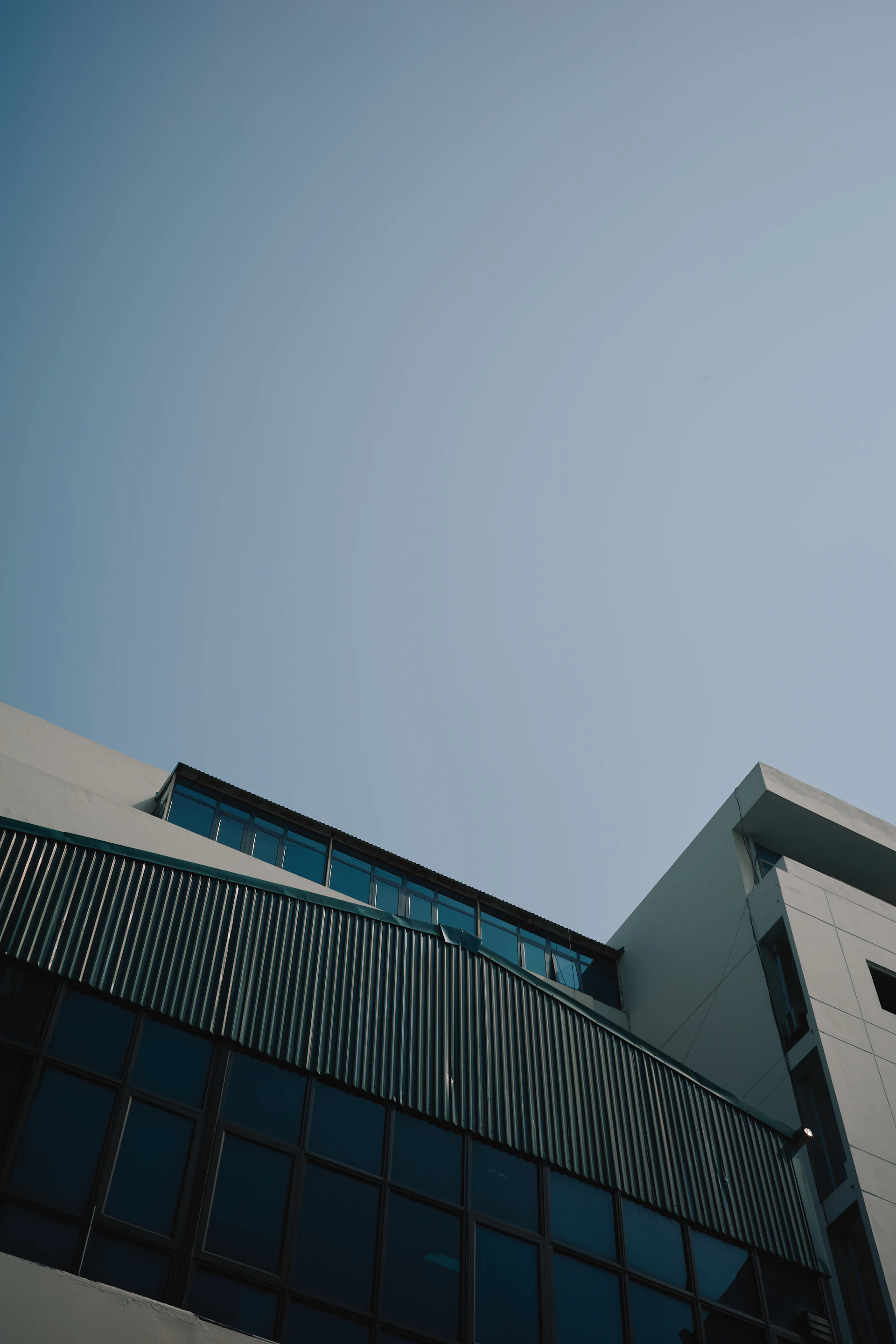 Modern building exterior with glass windows and clear sky