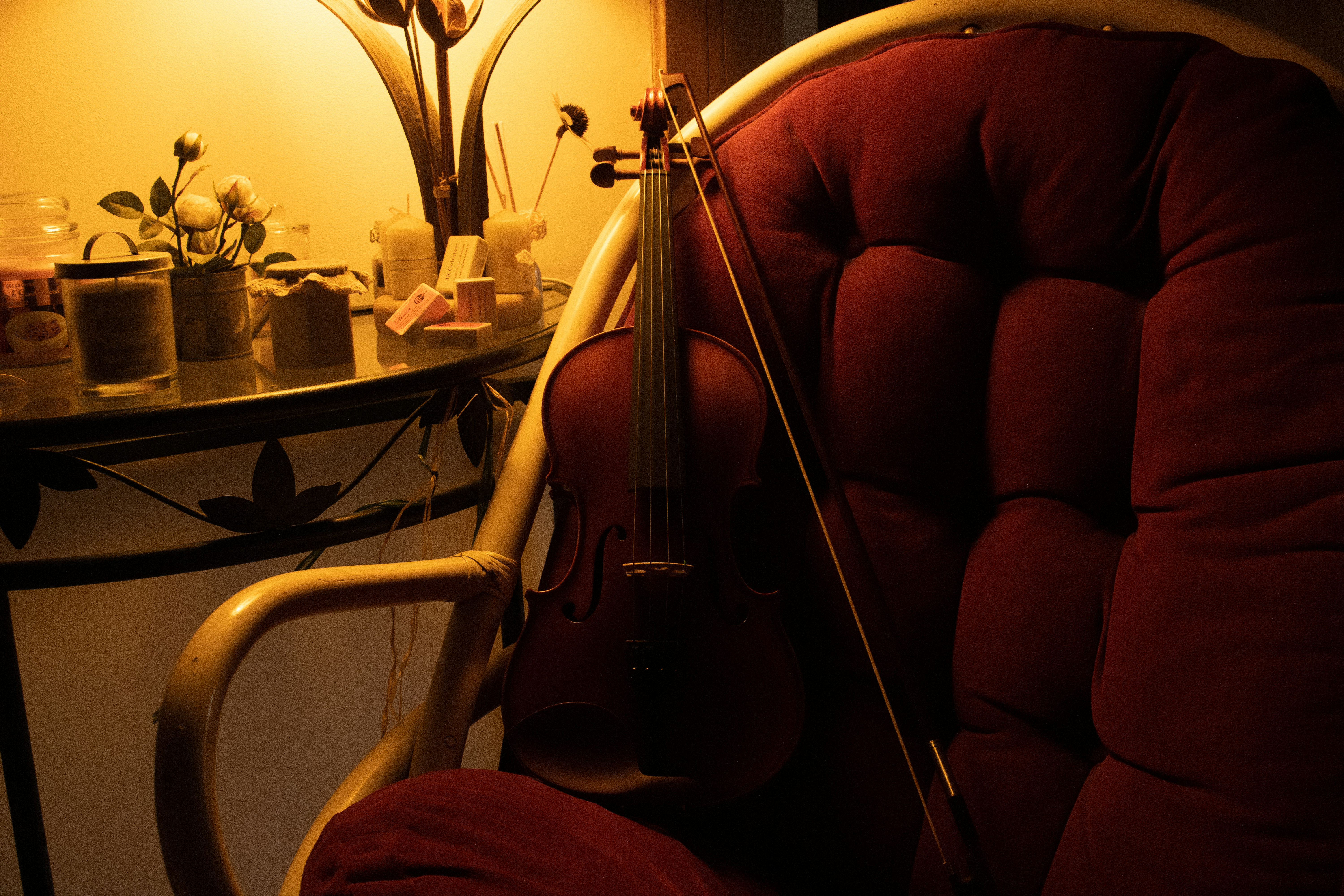 Violin and bow resting on a plush chair