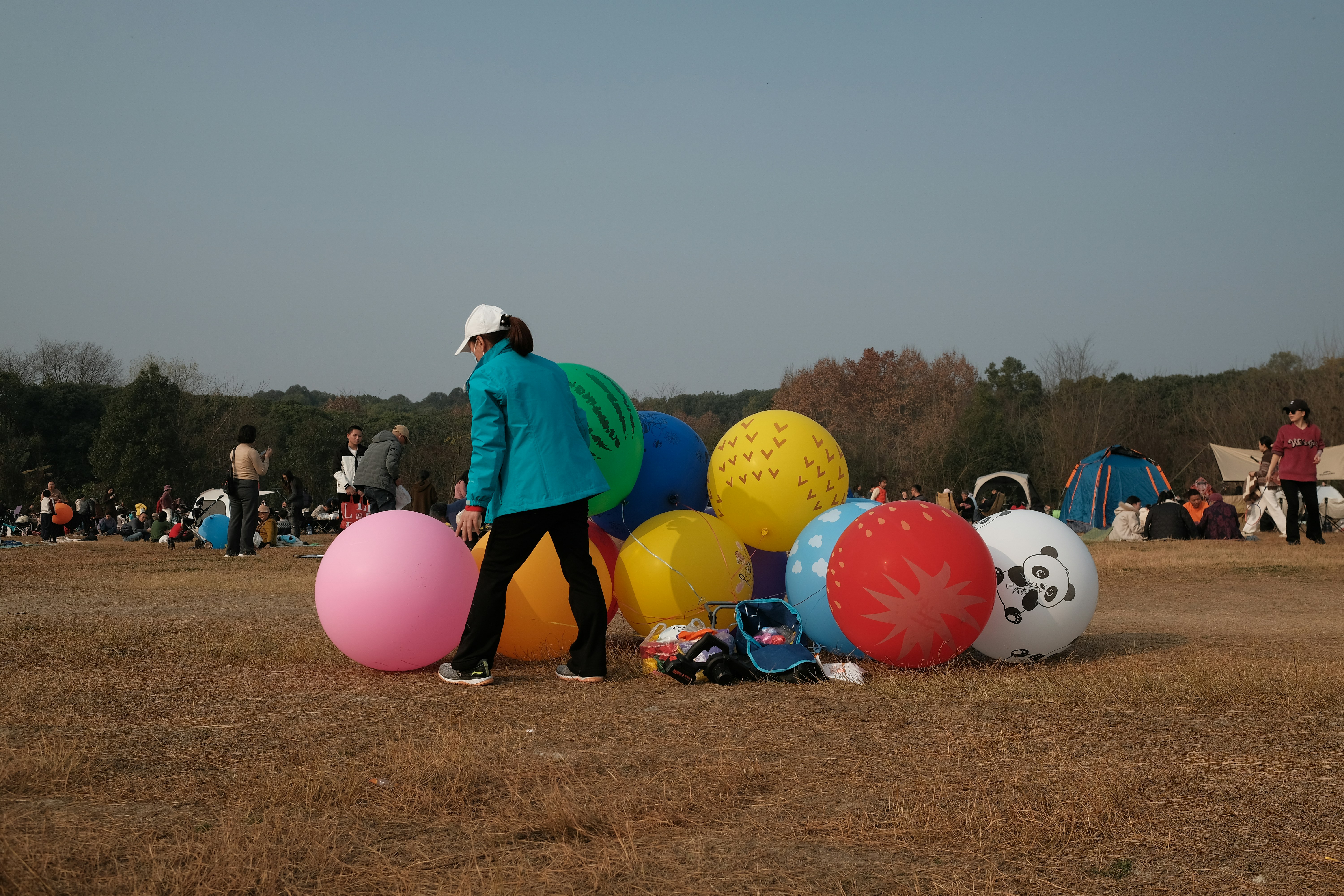 People gathered around large colorful inflatable balls outdoors