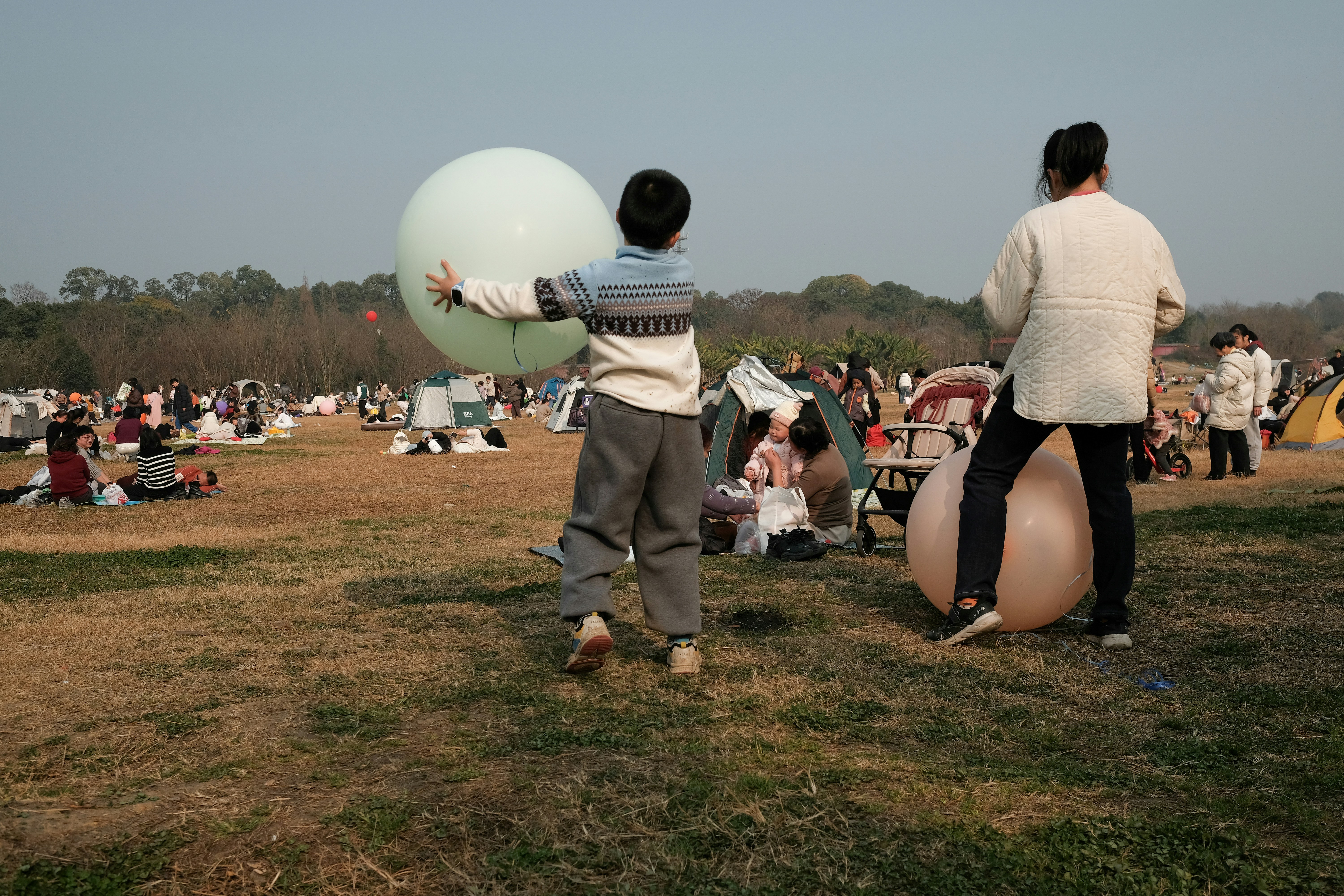 Children play with large balloons in a park