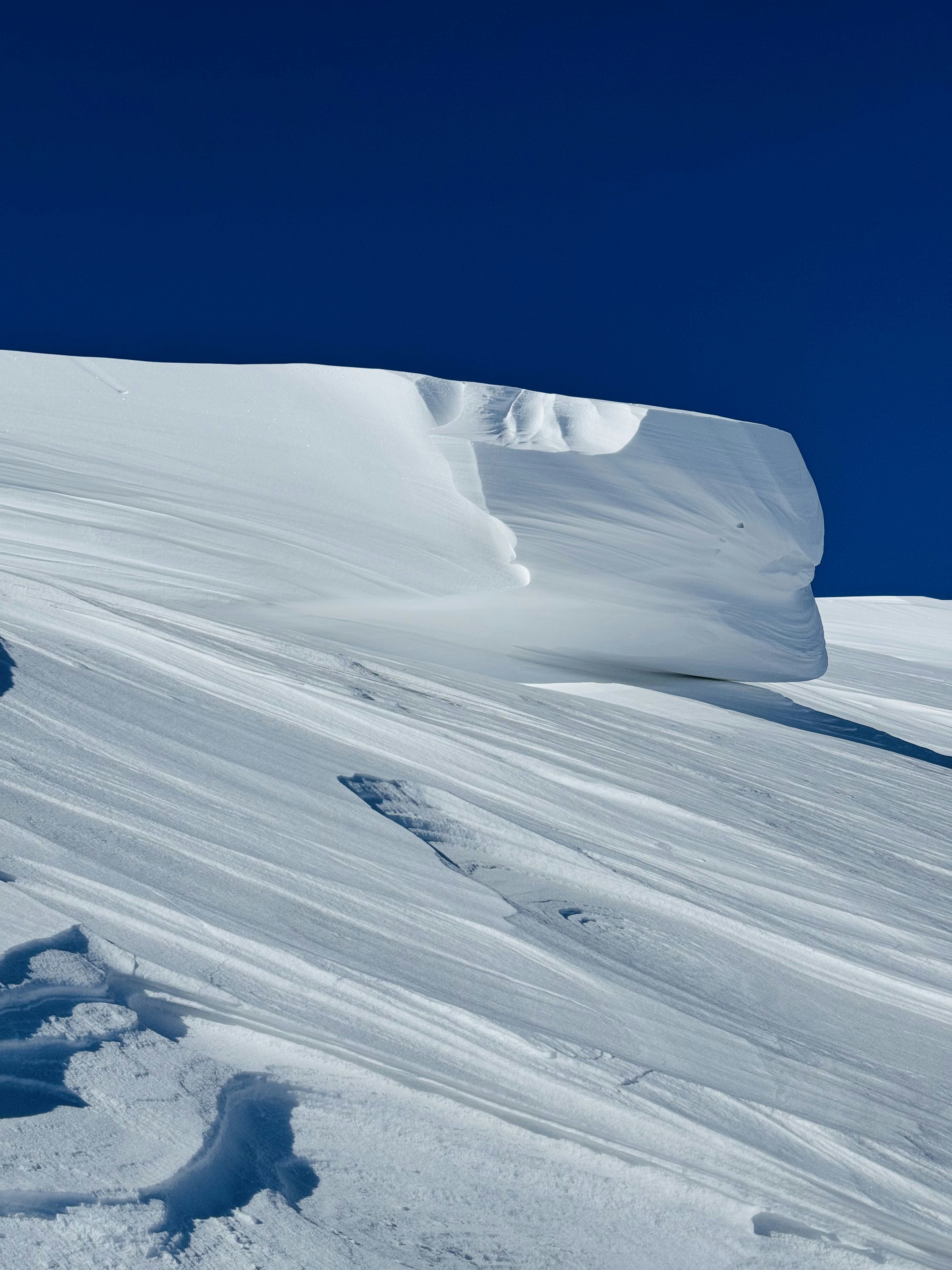 Pendio innevato di montagna con cielo azzurro limpido