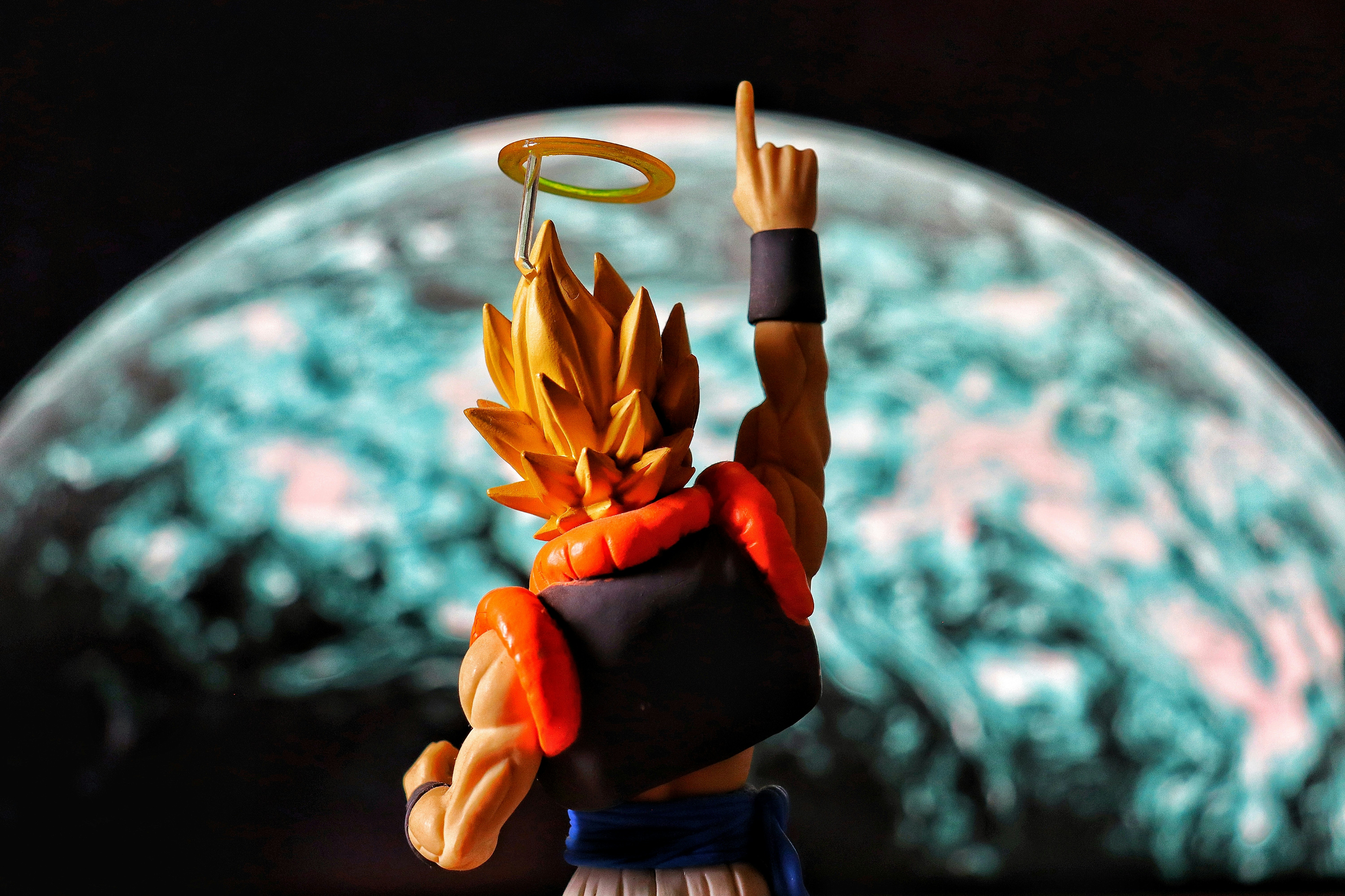 Anime figure pointing upwards with planet background