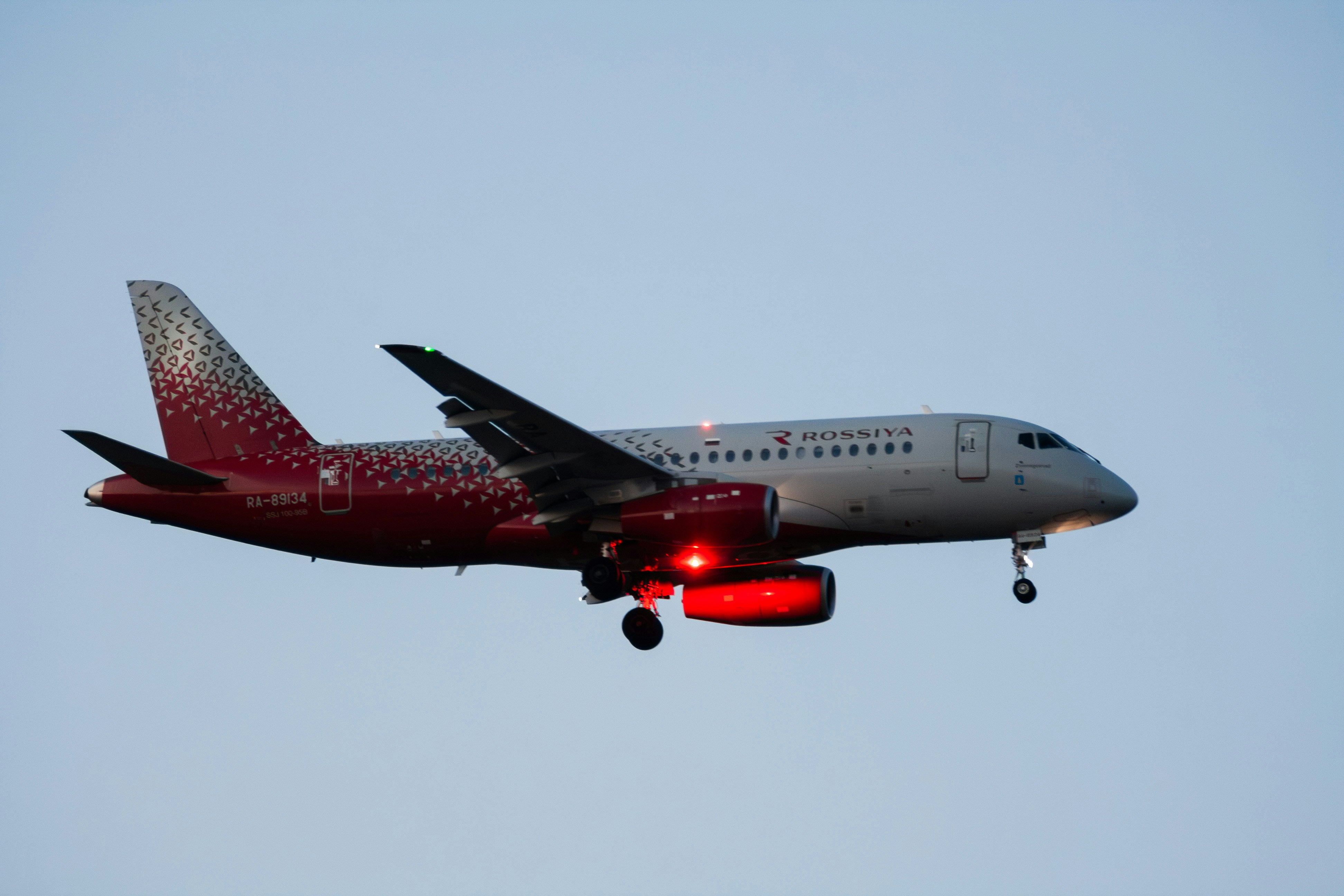 A red and silver airplane flying in the sky.
