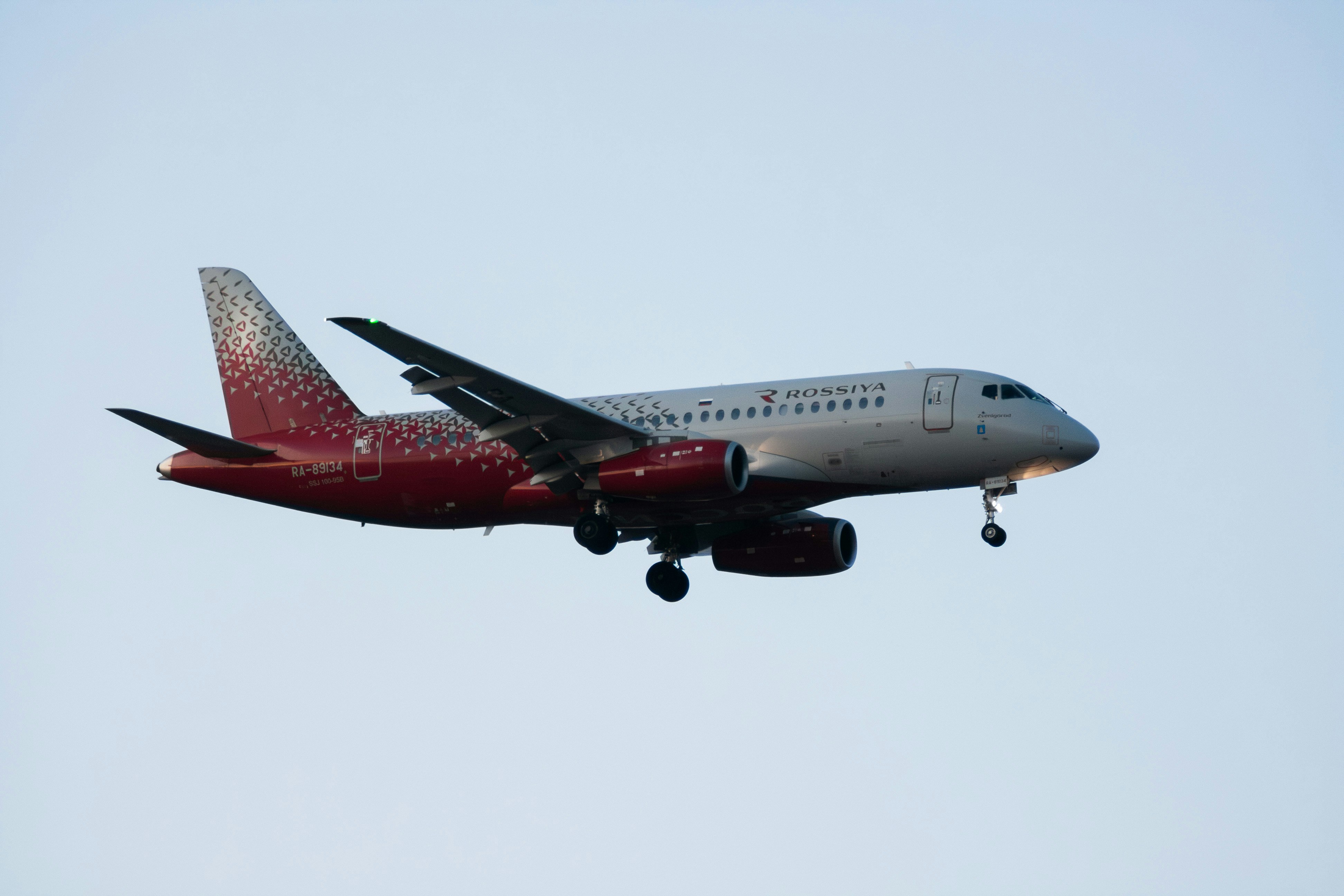 A red and white airplane flying in the sky