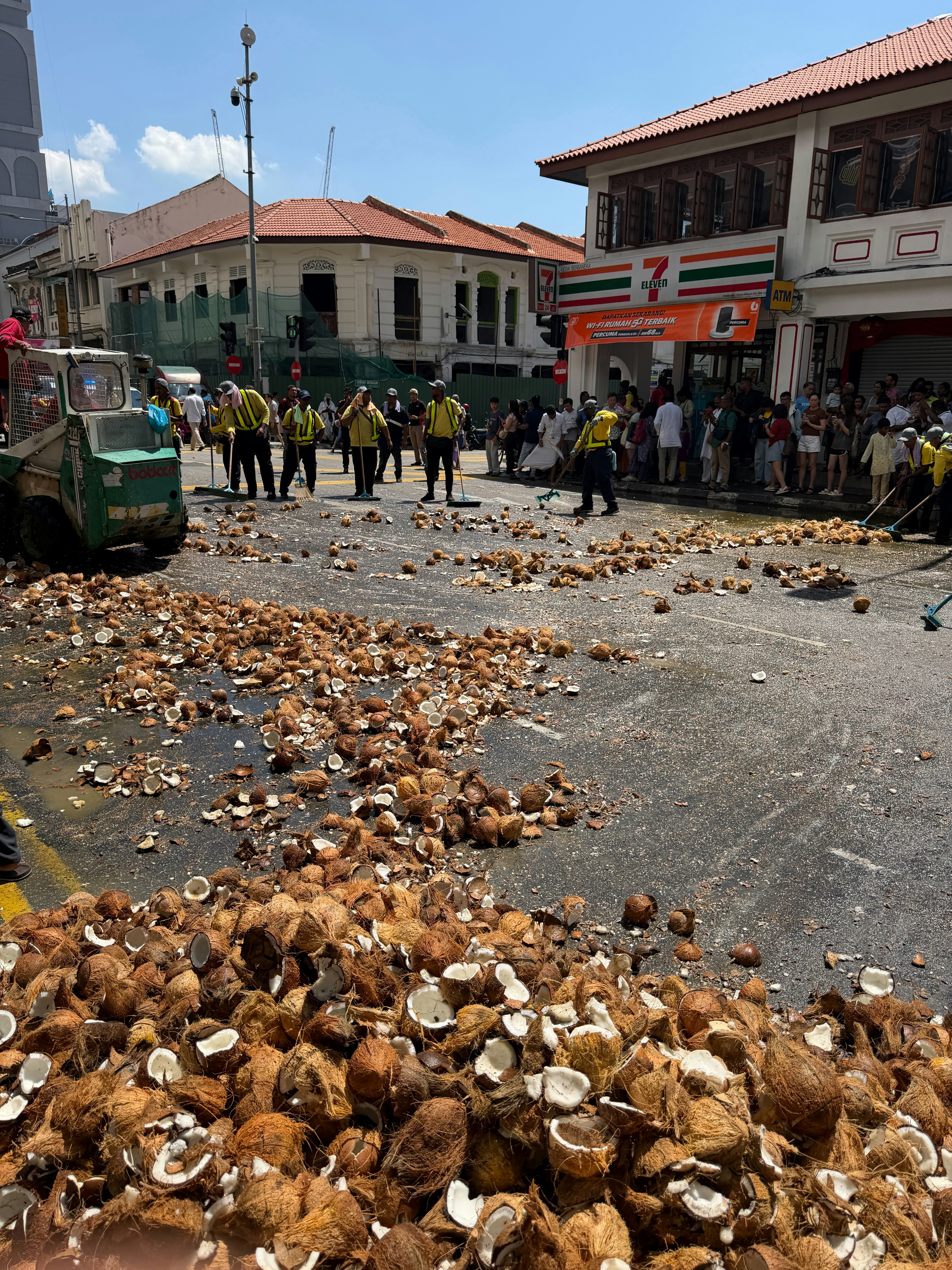 Kokosnüsse verstreut auf der Straße, während Leute putzen