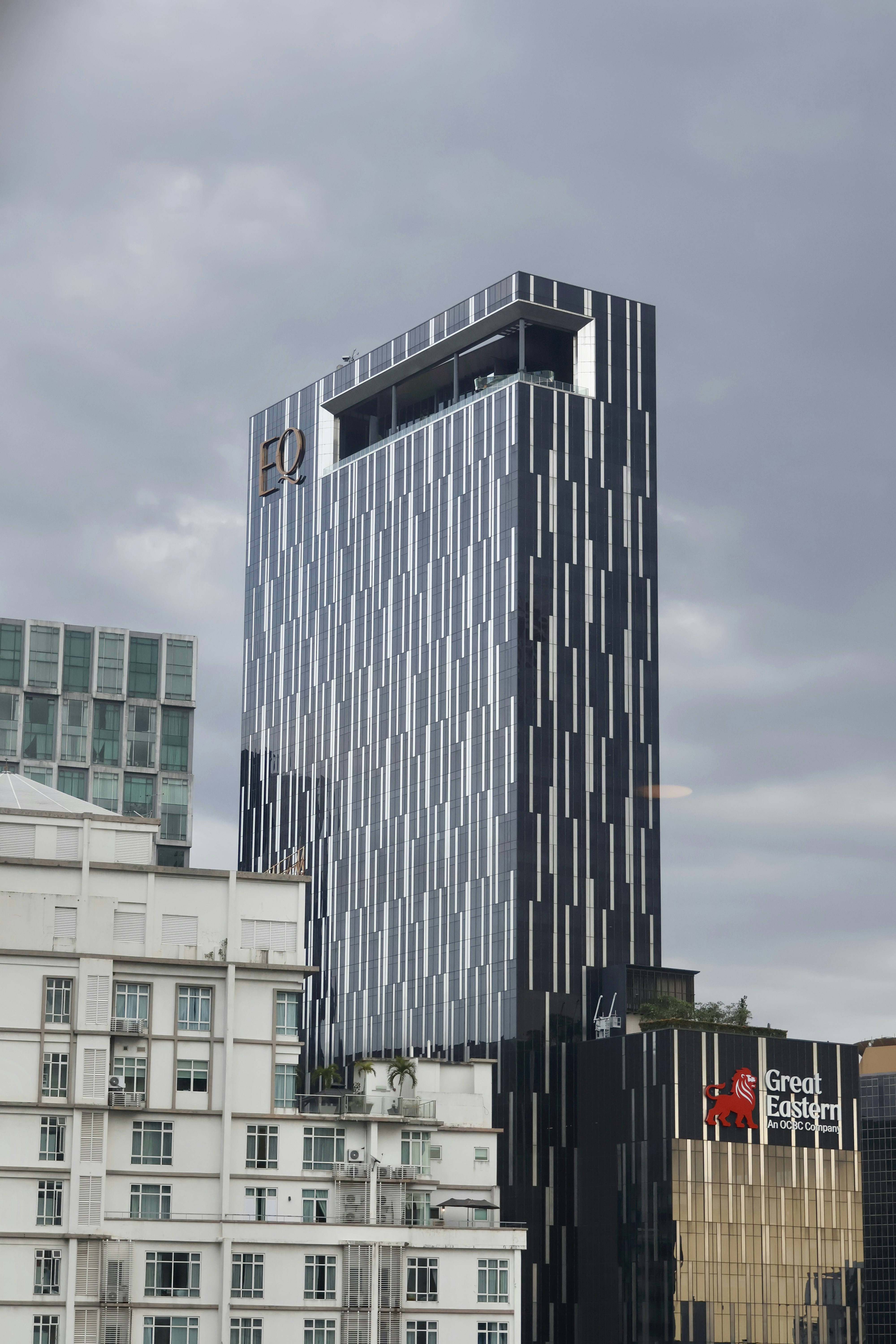 Modern skyscraper with a striped facade against a cloudy sky