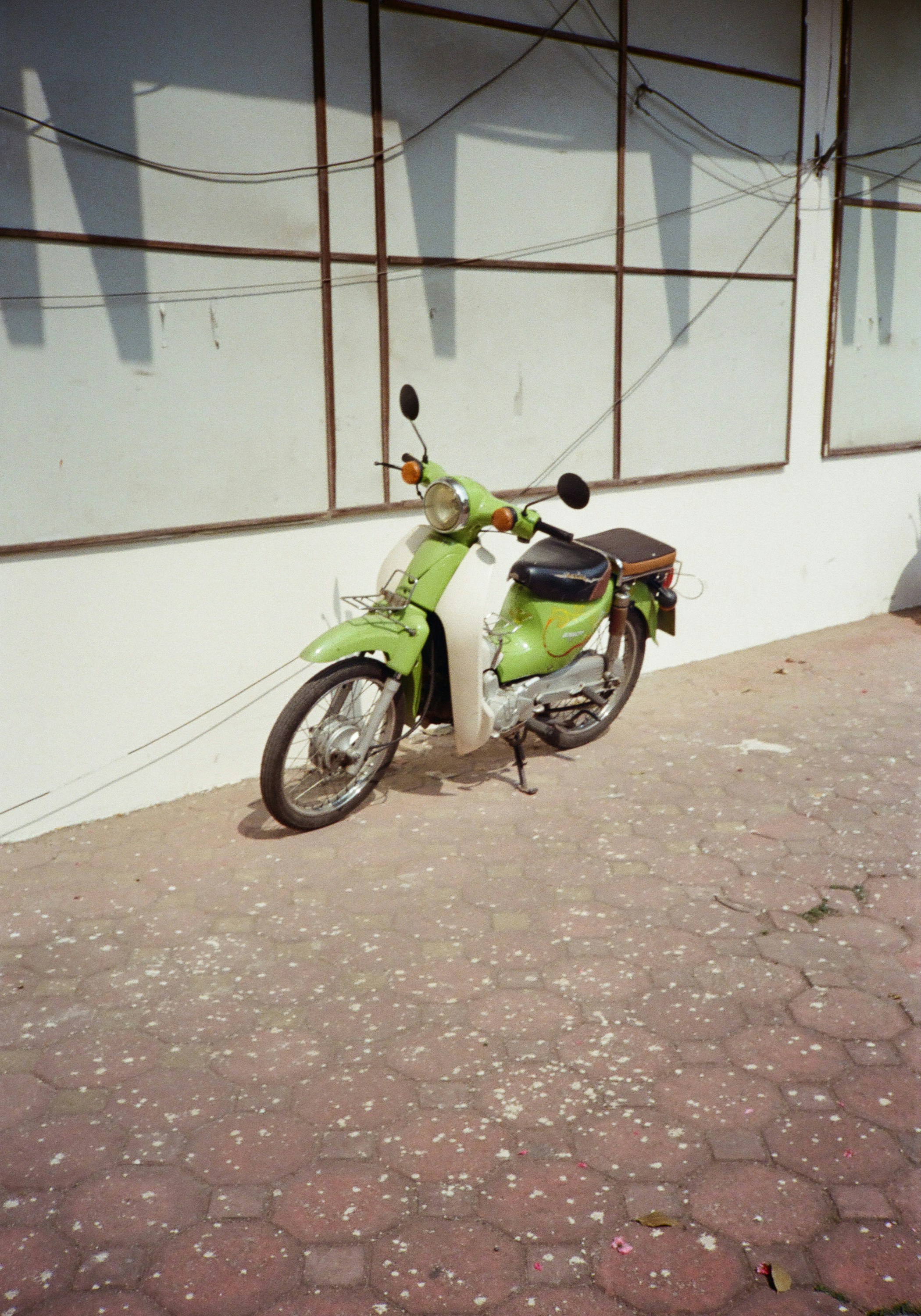 ヴィンテージの緑と白のスクーターが屋外に停まっていました。