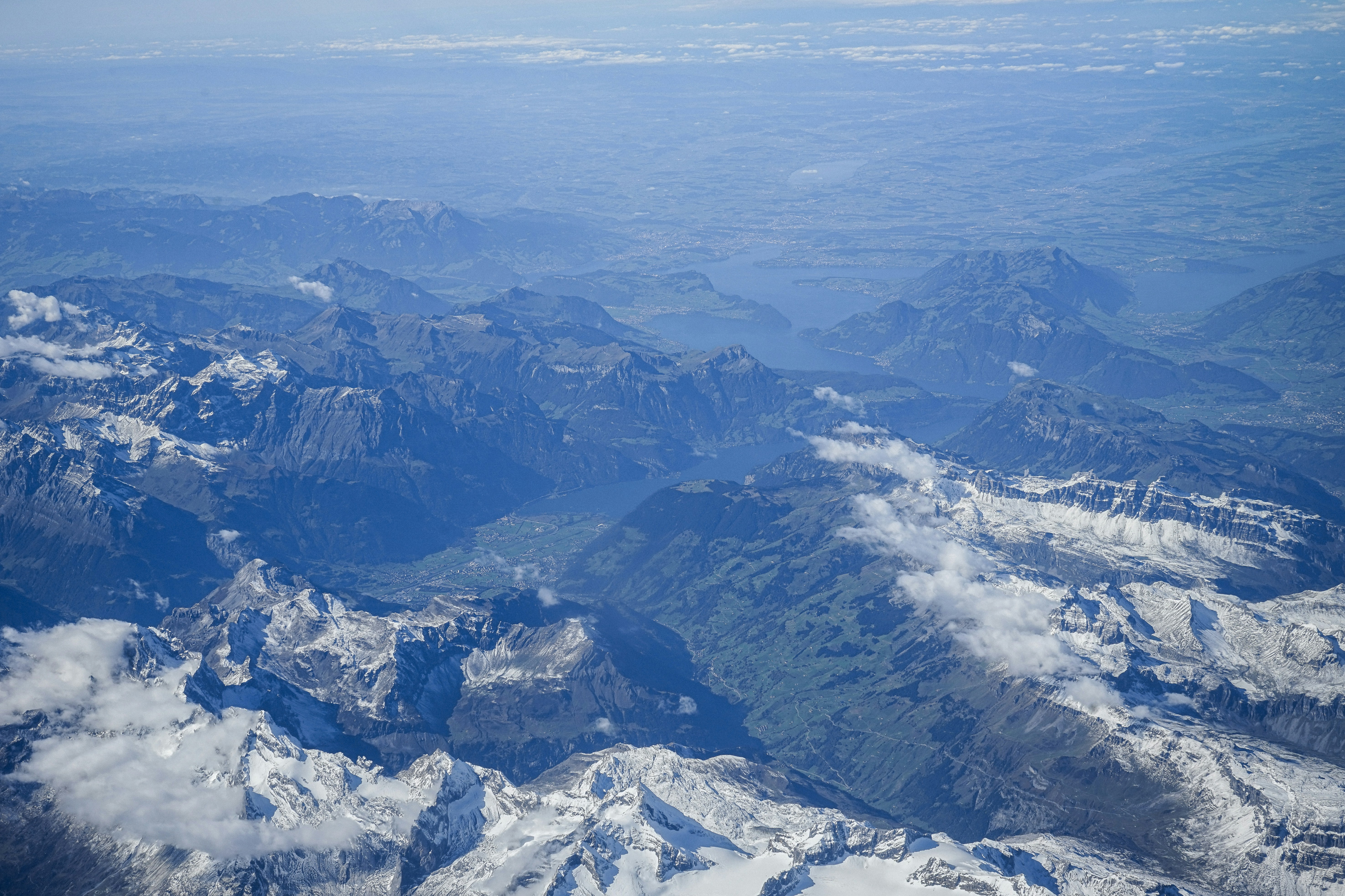 Snow-capped mountains under a hazy sky from above
