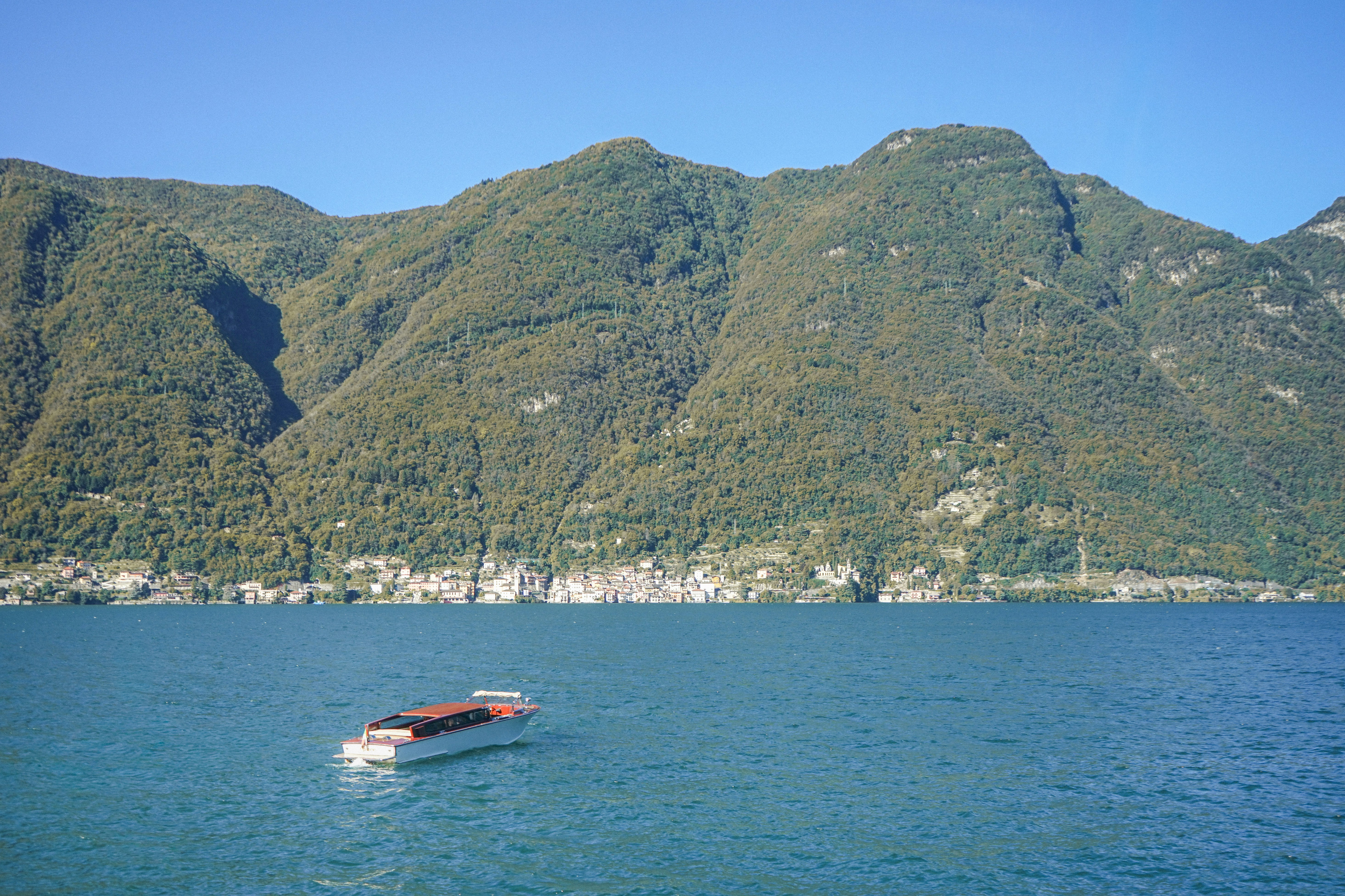 A boat on a lake with mountains in the background.