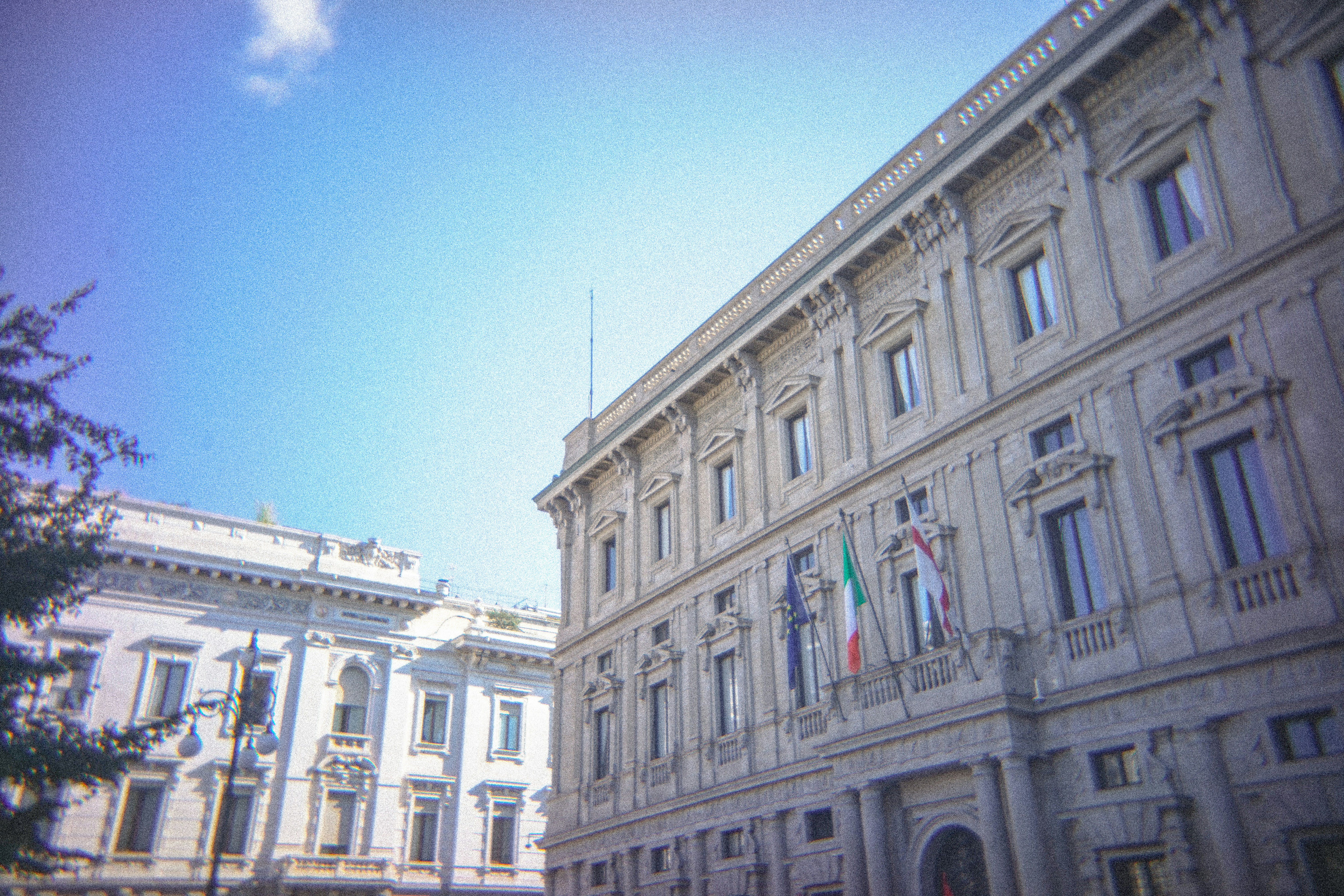 Ornate building facade with italian flag under blue sky