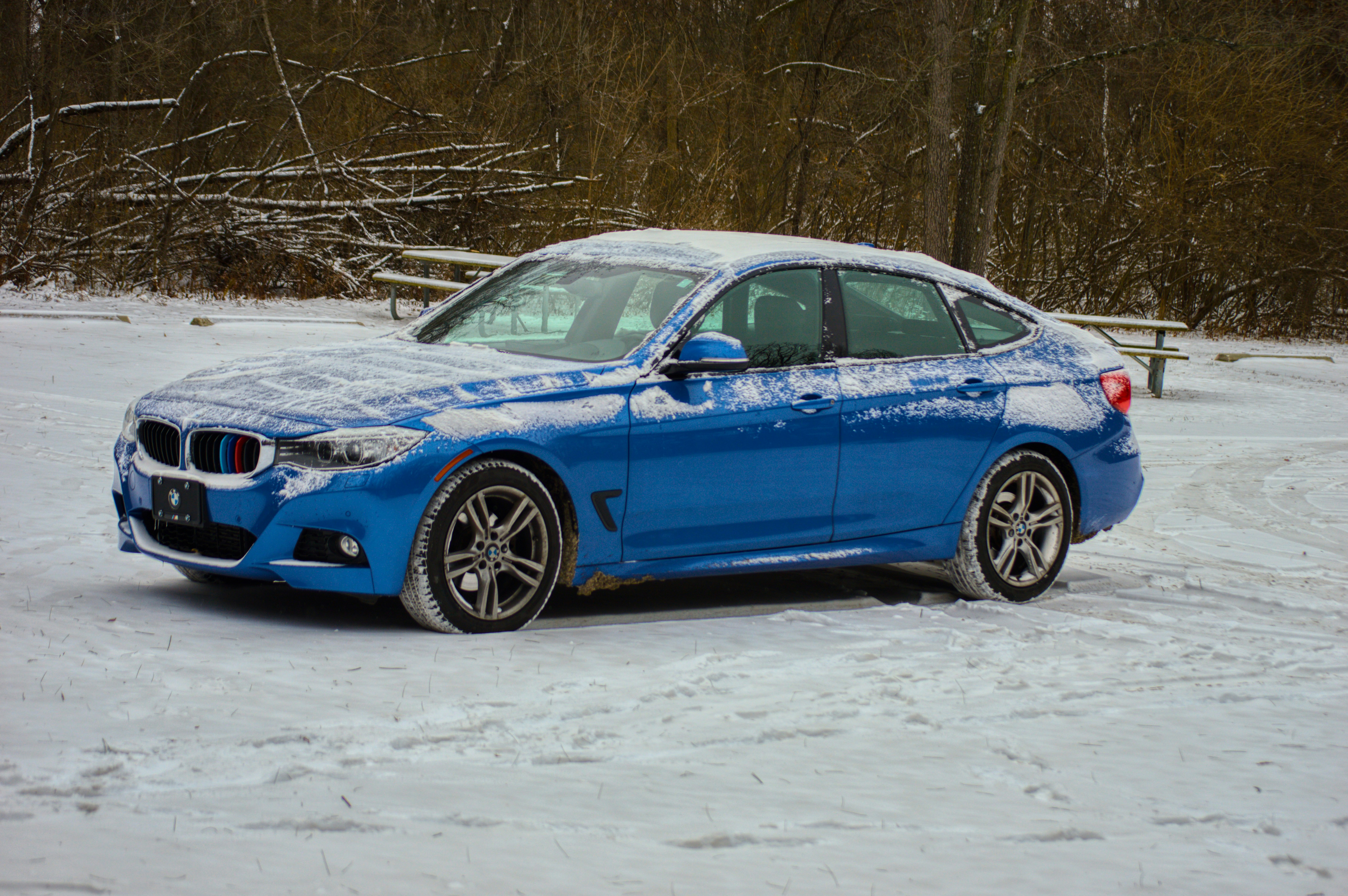 Un'auto blu parcheggiata in un paesaggio innevato.