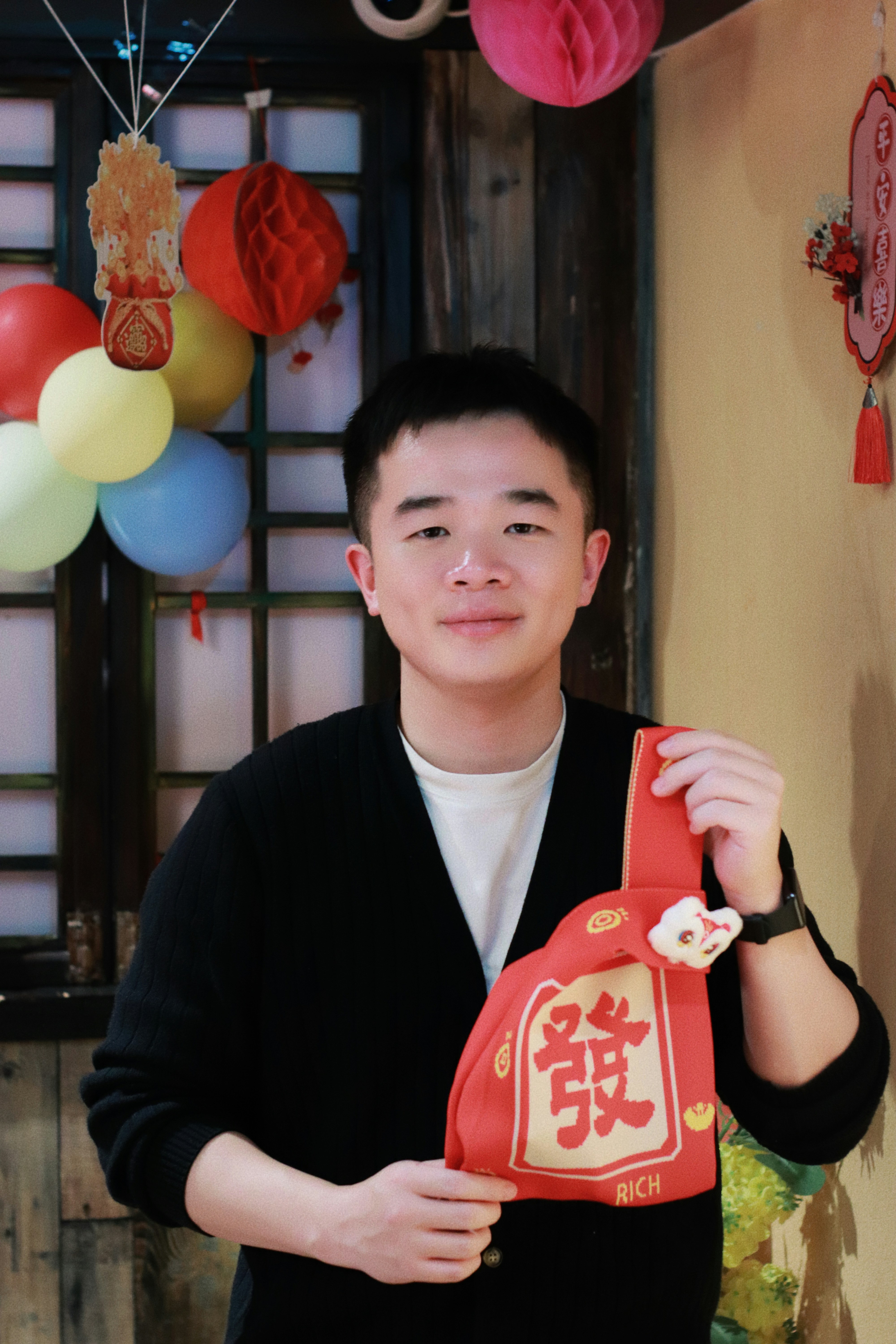 Man holding a red pouch with chinese characters.