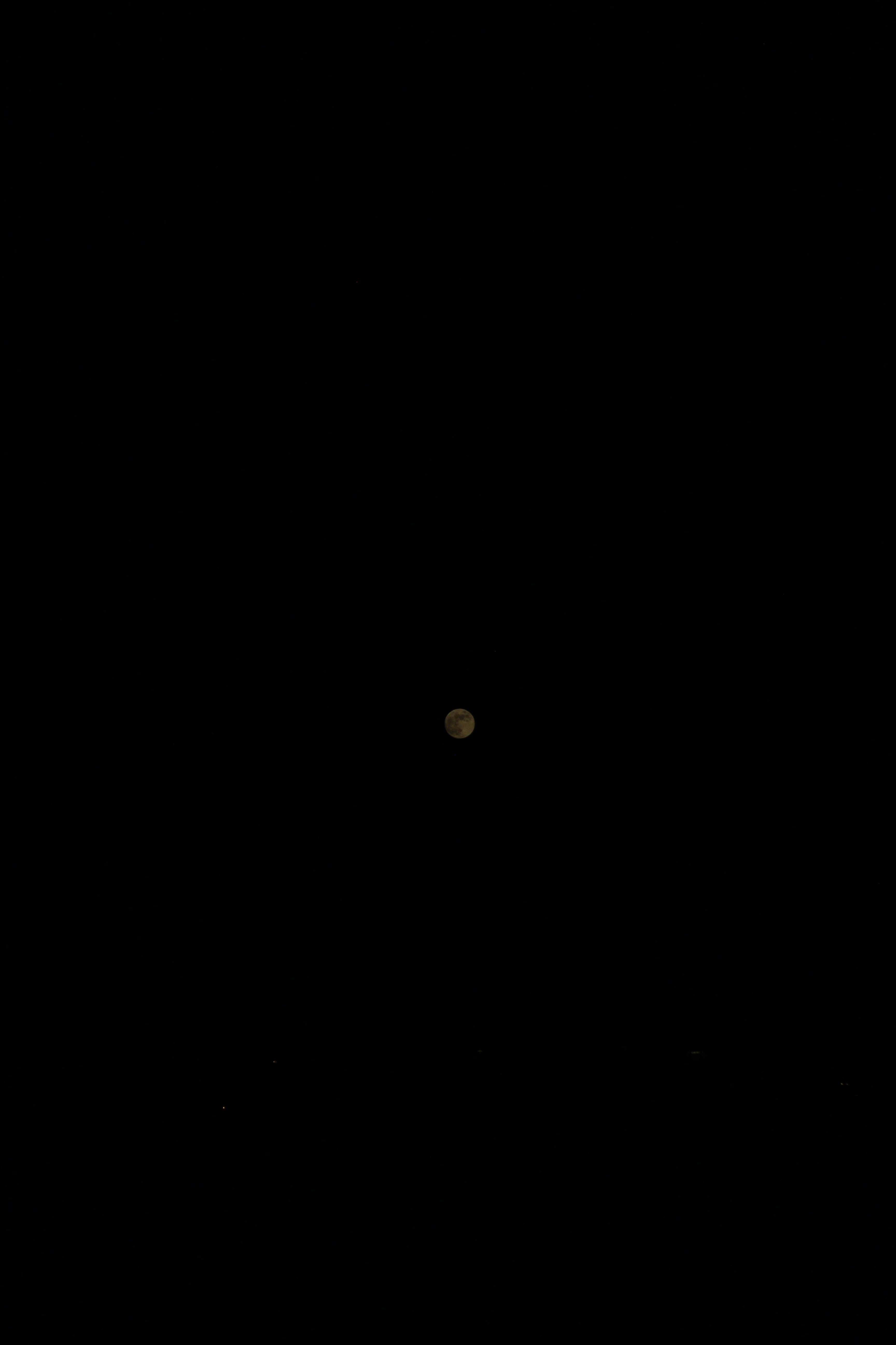 A small moon in a vast black sky