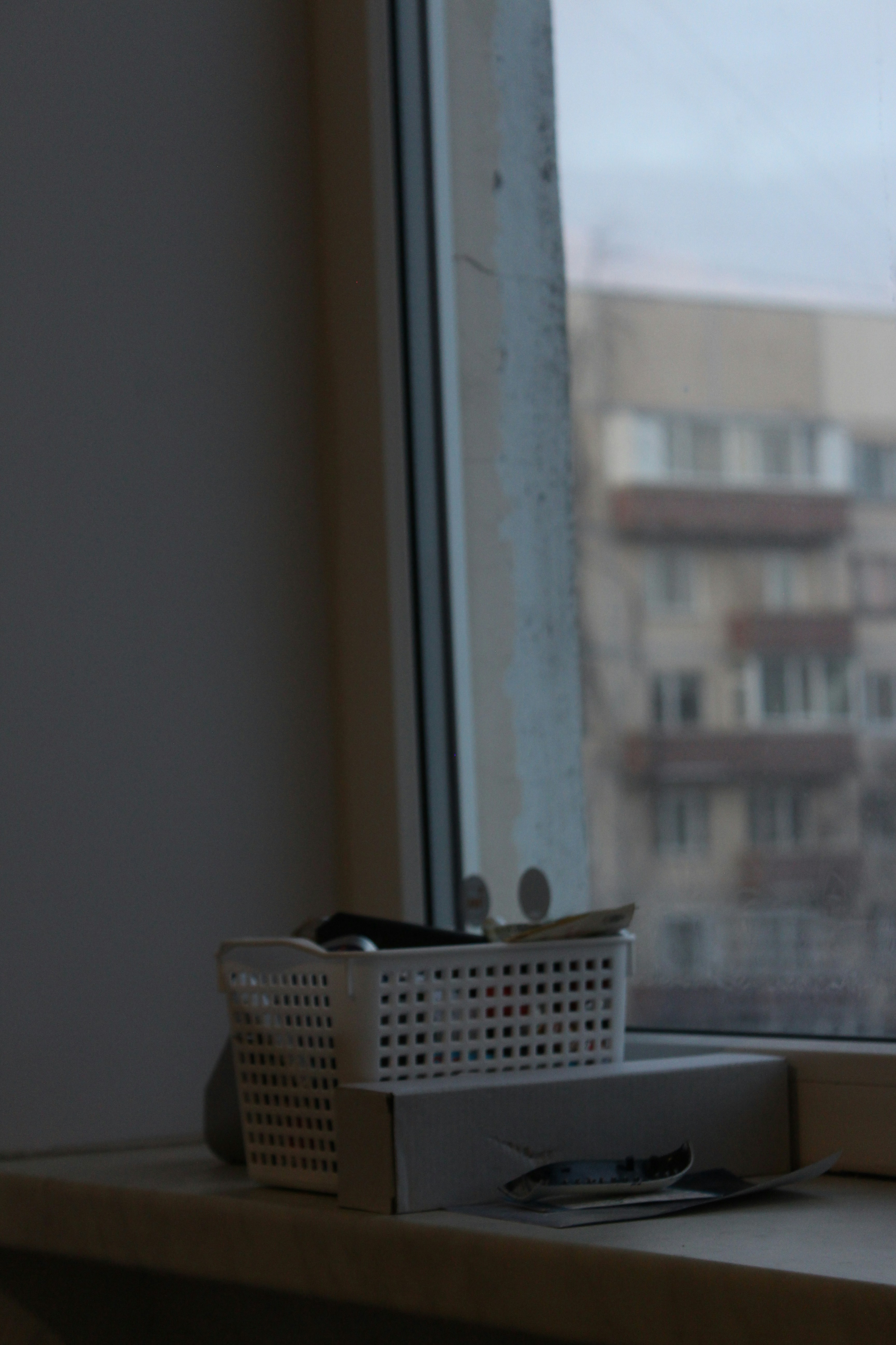 White basket on windowsill with urban background