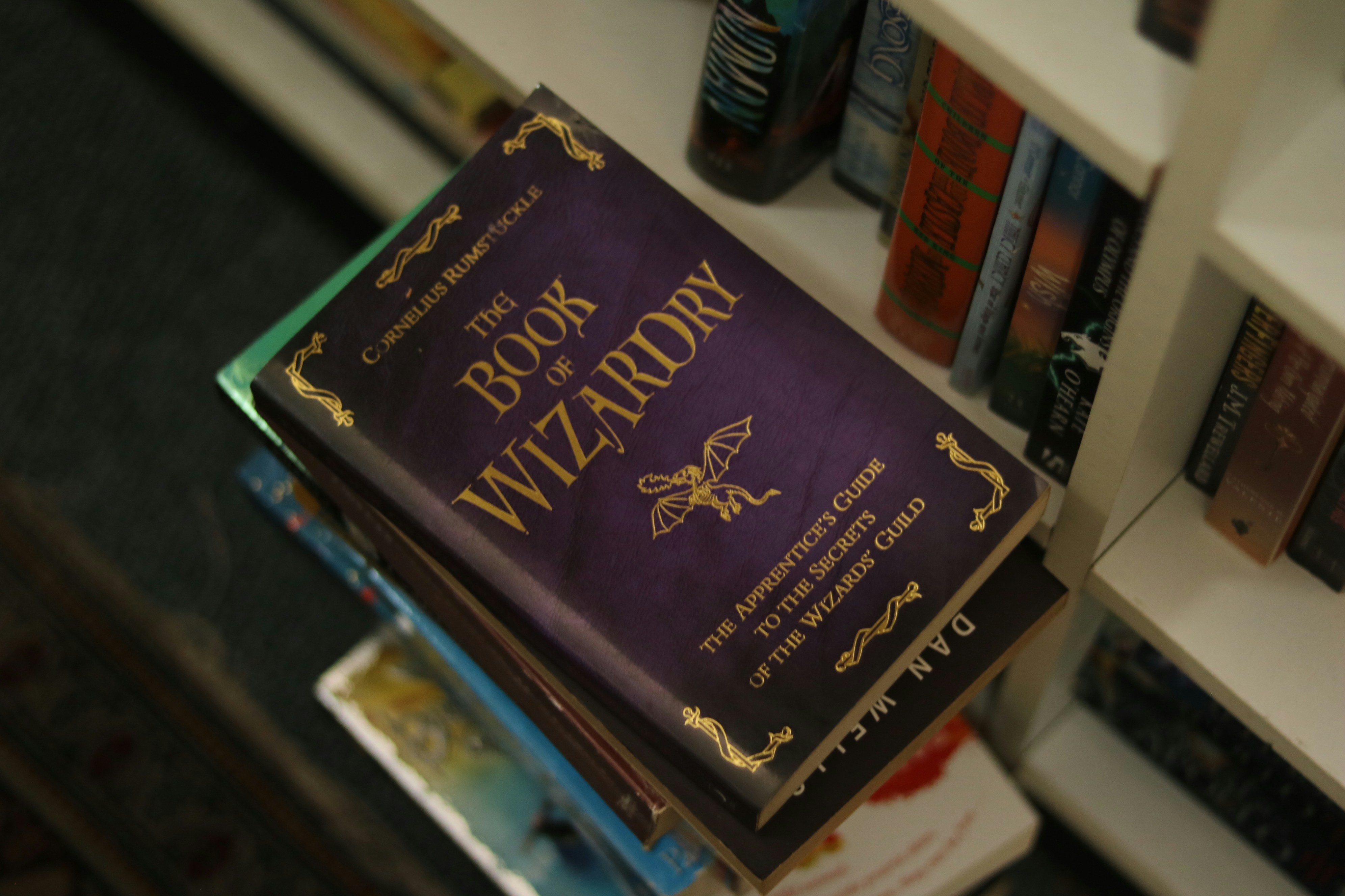 The book of wizardry rests on a stack of books.