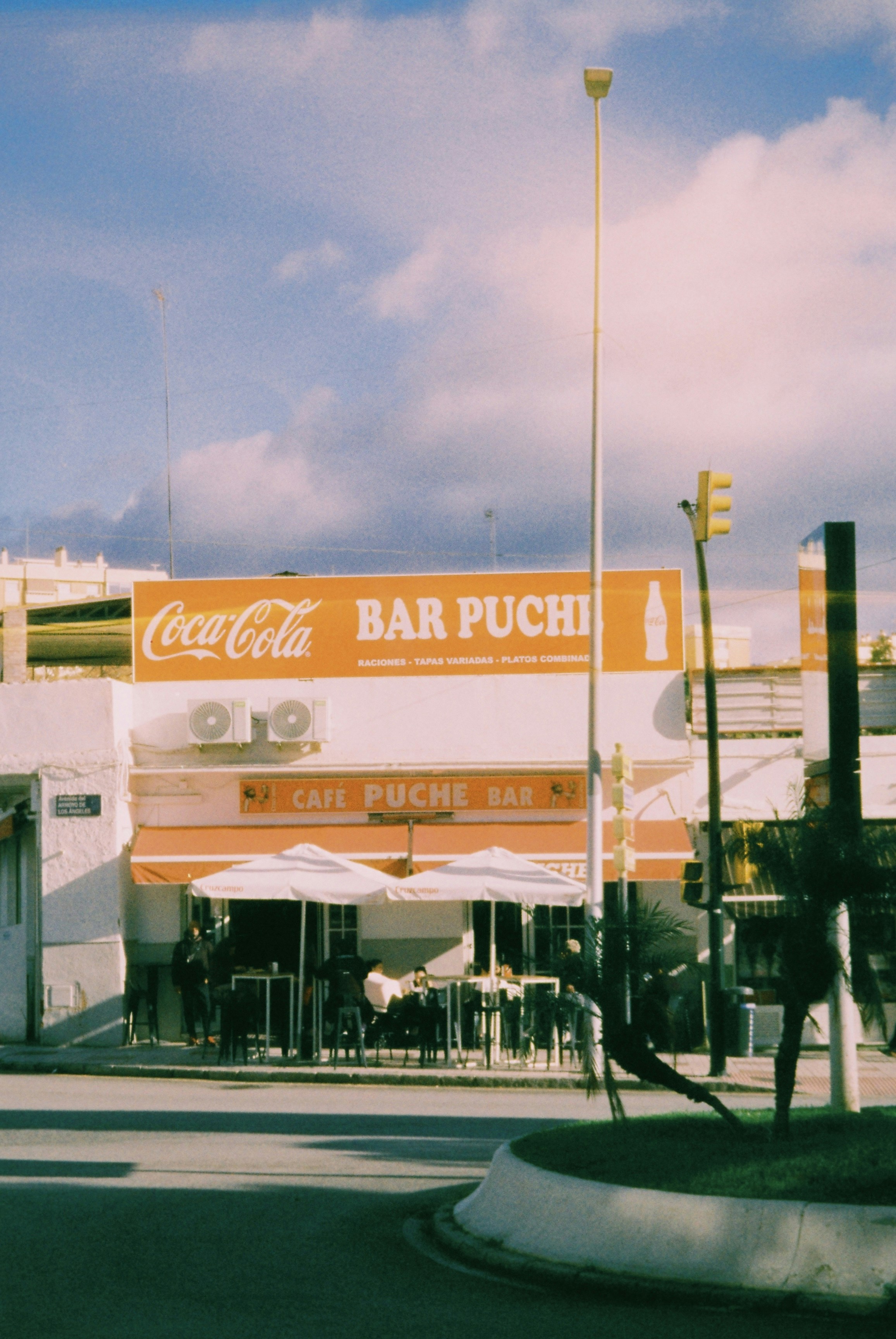 Café mit Coca-Cola-Schild und Außensitzplätzen