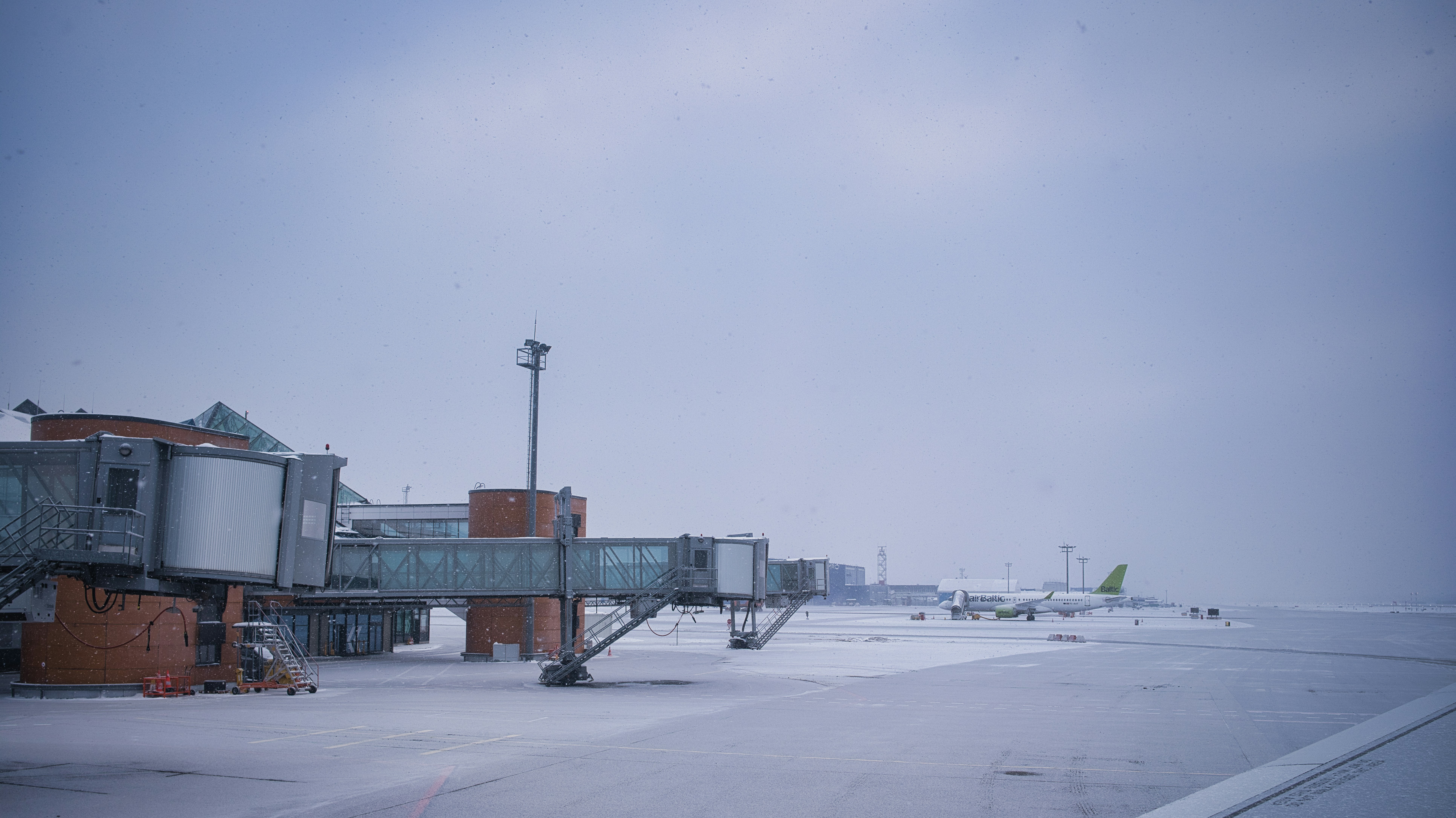 Jet bridges and airplane on snowy airport tarmac