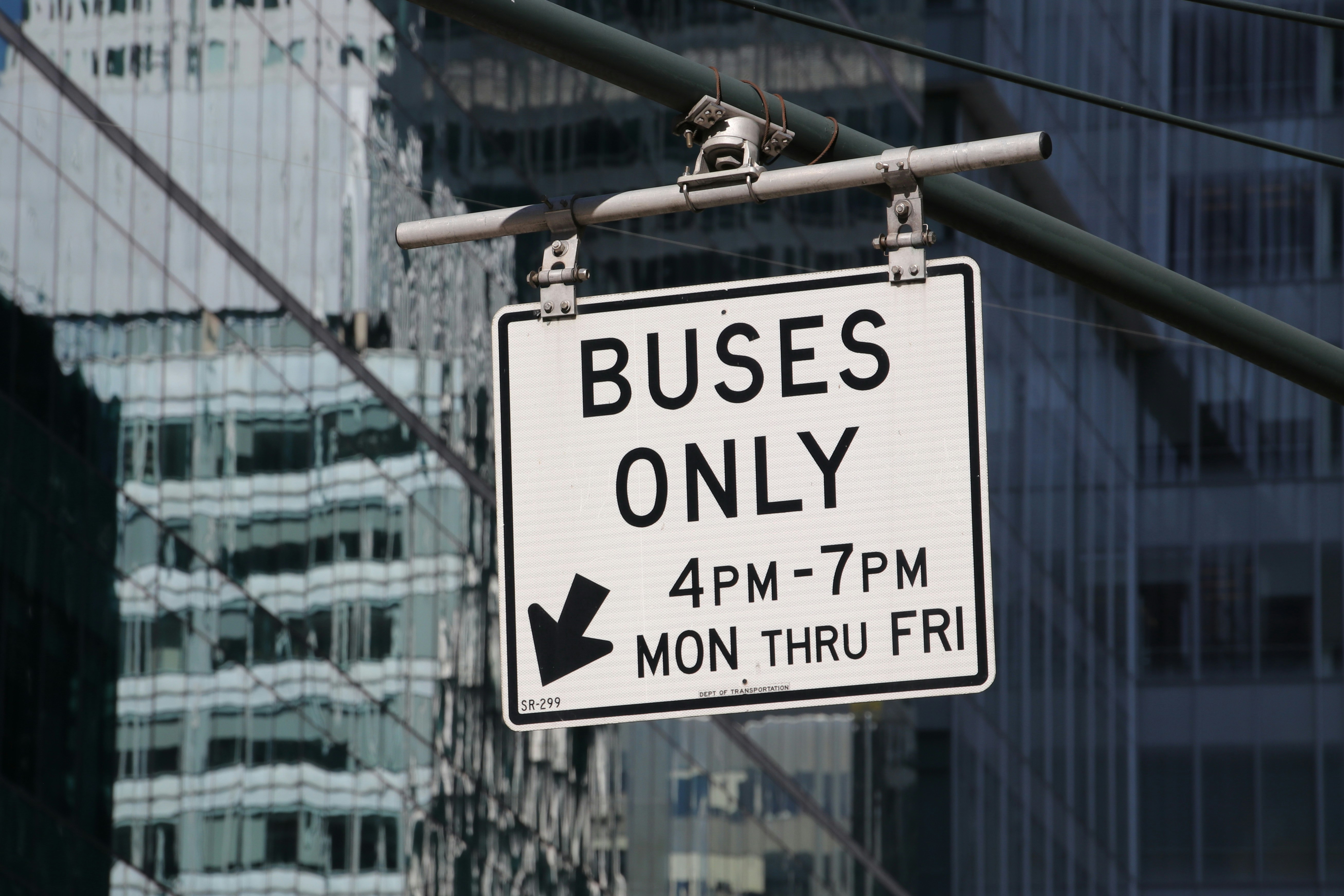 Buses only sign with arrow and times