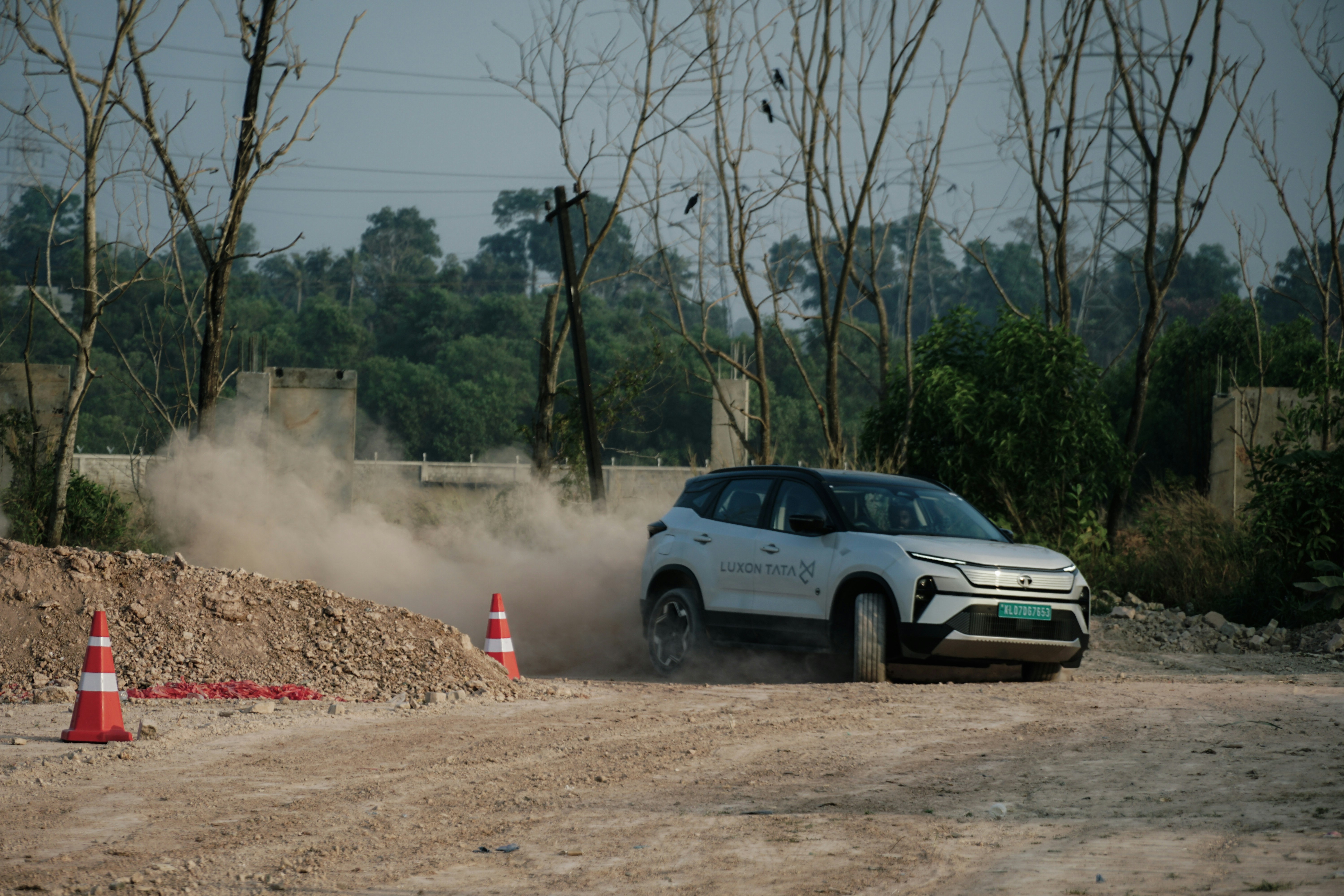 White suv kicking up dust on a dirt road