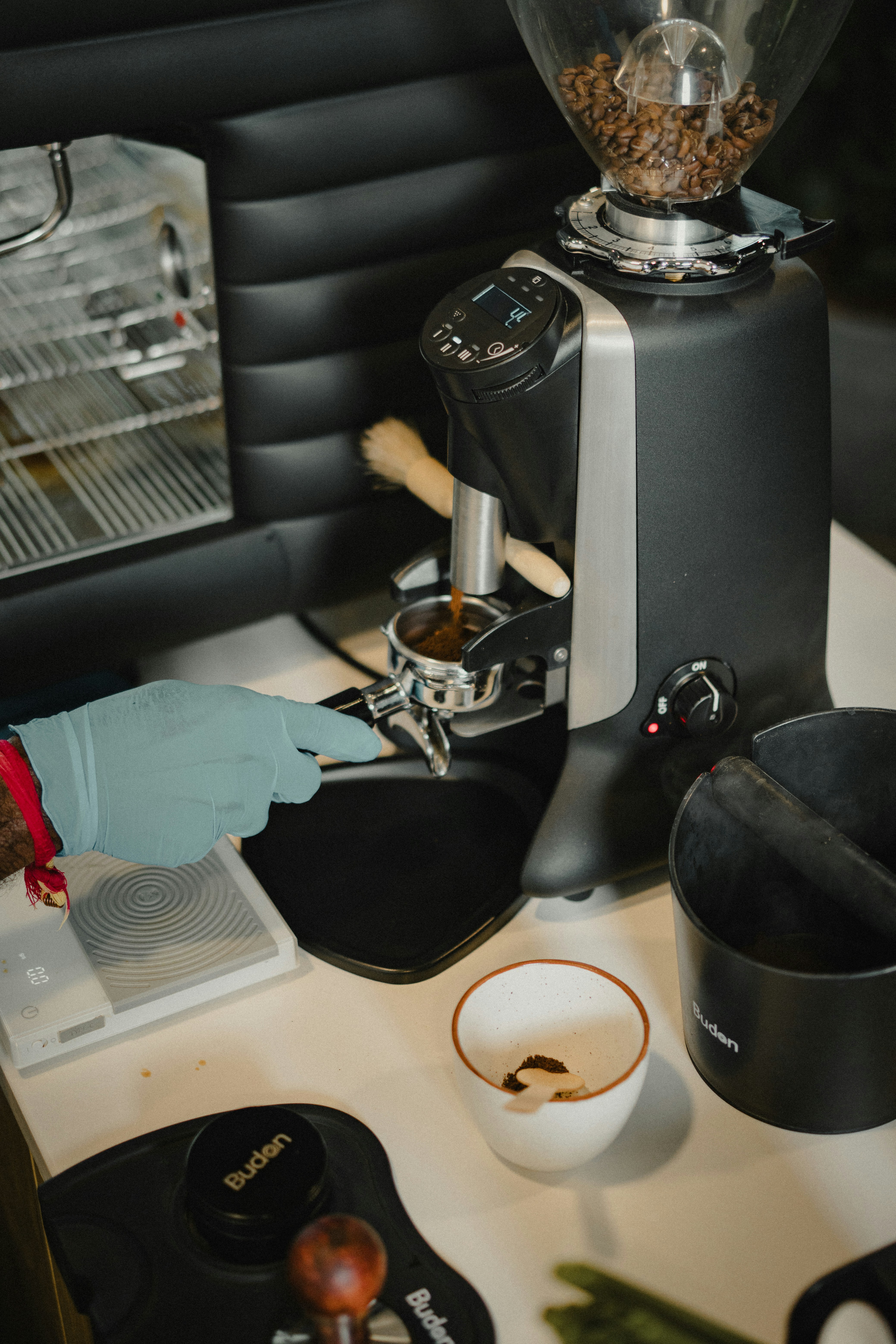 Barista memadatkan bubuk kopi ke dalam portafilter dengan penggiling