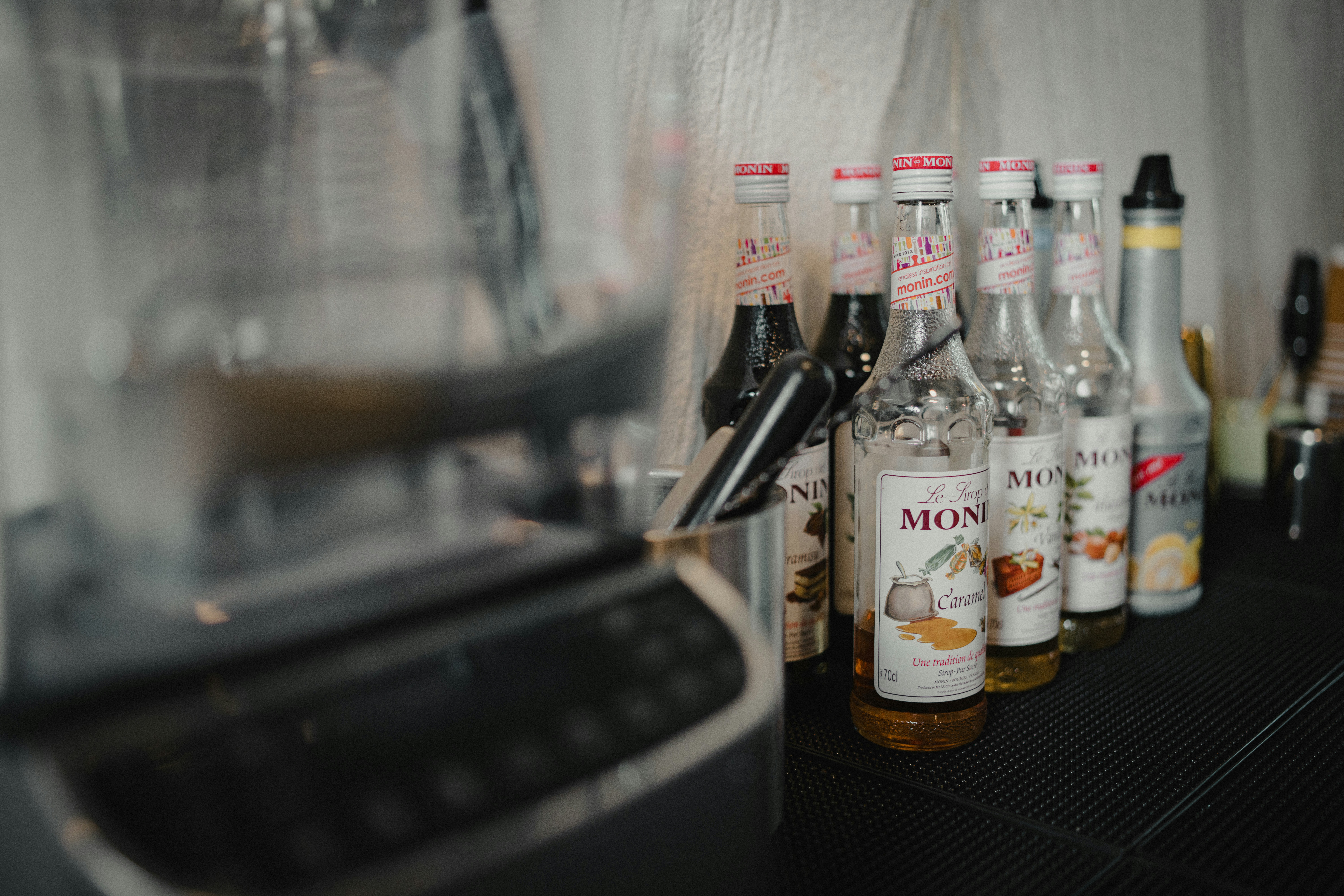 Bottles of flavored syrups lined up on a counter.